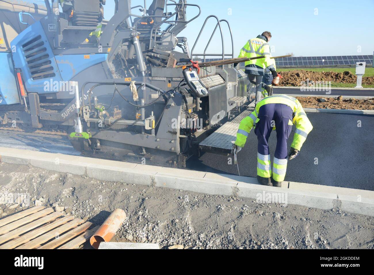 Ein Auftragnehmer mit dem belgischen Bauunternehmen WANTY überprüft die Dicke der Asphaltschicht während des Baus eines Verkehrskreises auf dem Luftwaffenstützpunkt Chièvres, Belgien, 19. März 2021. Stockfoto