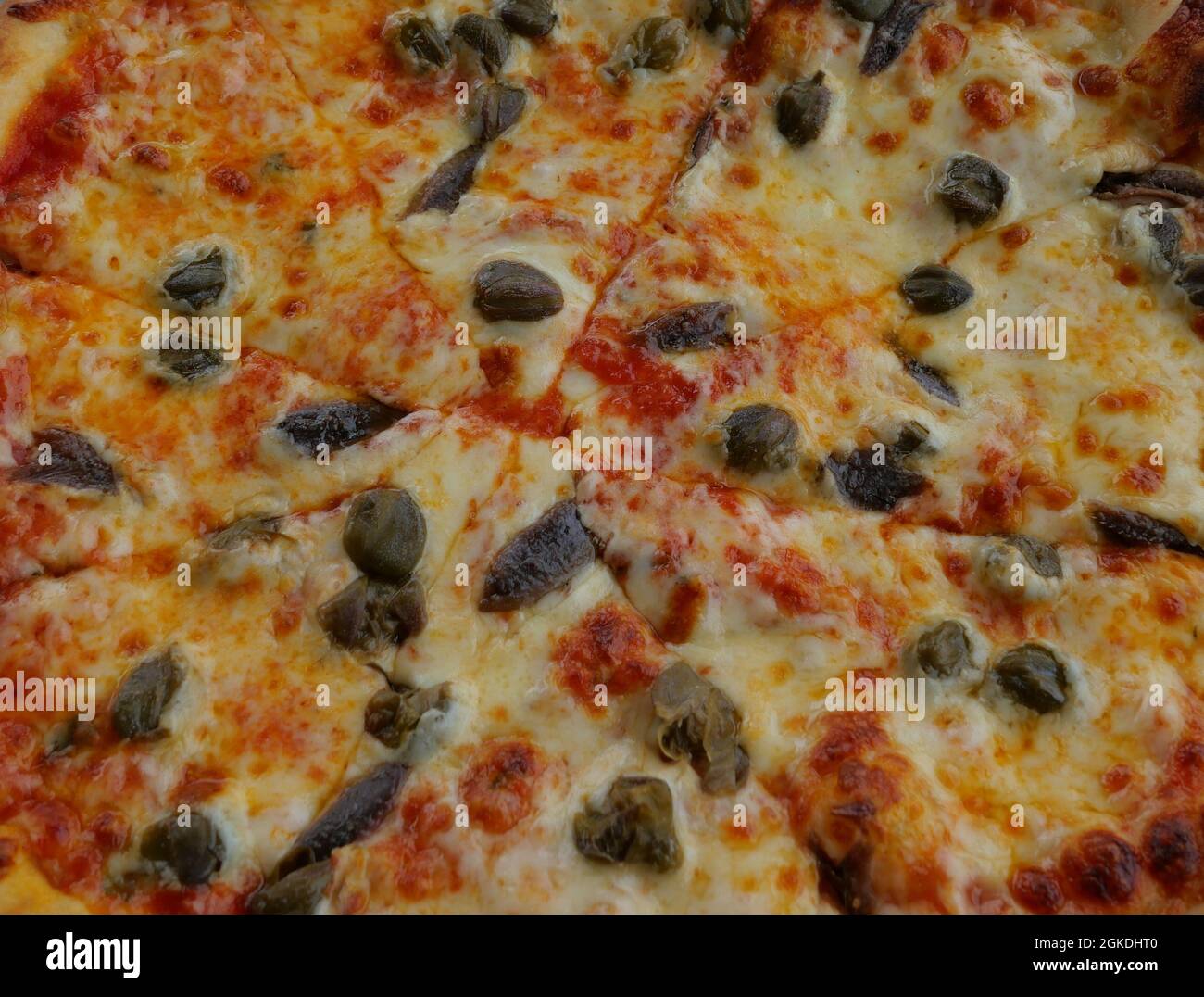Blick auf die Pizza von oben mit Oliven, Sardellen und Kapern Stockfoto