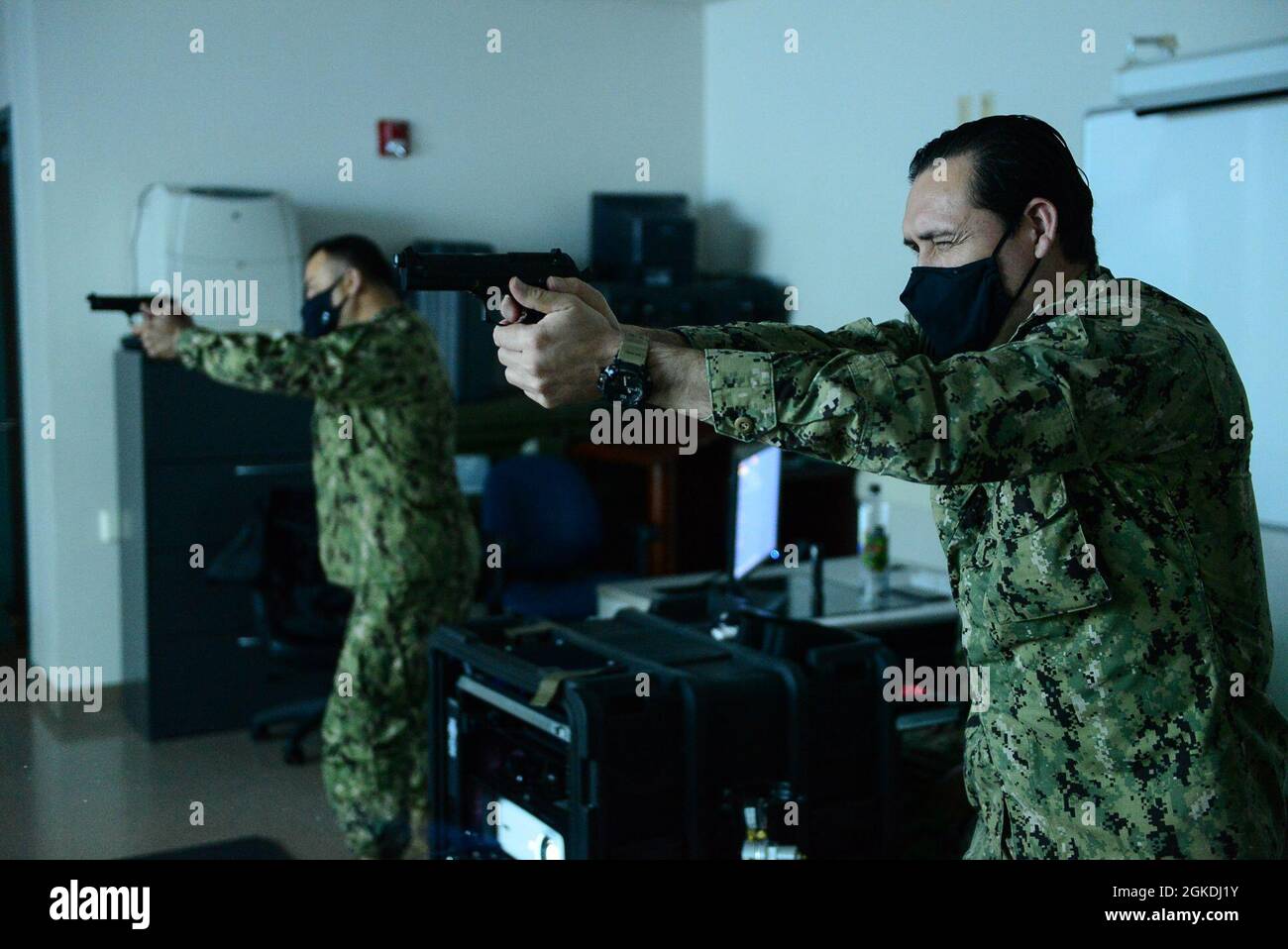 FORT WORTH, Texas (März 23, 2021) - Master-at-Arms First Class Juan Escamilla (rechts), ein Marinereservesegler, der dem Navy Operational Support Center (NOSC) Harlingen zugewiesen wurde, Und Master-at-Arms First Class Ruben Palleres, angeschlossen an das Marine Operational Support Center El Paso, nehmen an halbjährlichen Small Arms Sustainment Training Training auf einer Fire Arm Training Simulator (FATS) Maschine im Navy Region Southeast Reserve Component Command Fort Worth Teil. Die Fortbildungsmaßnahmen sind eine navy-weite Voraussetzung für alle Segler, die als bewaffnete Wachtler bezeichnet werden. Stockfoto