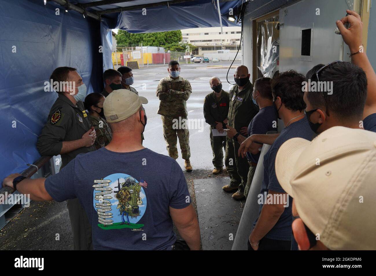 Flieger der 15. Medizinischen Gruppe und Navy Diver von der Joint Base Pearl Harbor-Hickam überprüfen die Erfahrungen, die nach einer abgeschlossenen Übung auf der Navy Yard Pearl Harbor auf der Joint Base Pearl Harbor-Hickam, Hawaii, 23. März 2021, gewonnen wurden. Flieger, Navy Divers und Mitglieder der JBPHH Federal Fire Department reagierten auf einen simulierten Notfall während des Fluges und eskortierten ein Mitglied der Luftbesatzung zur Behandlung in die hyperbare Rekompression-Kammer. Die Übung half dabei, die Reaktionszeiten und Verfahren aller beteiligten Mitglieder zu messen, um sich auf einen realen Notfall vorzubereiten. Stockfoto