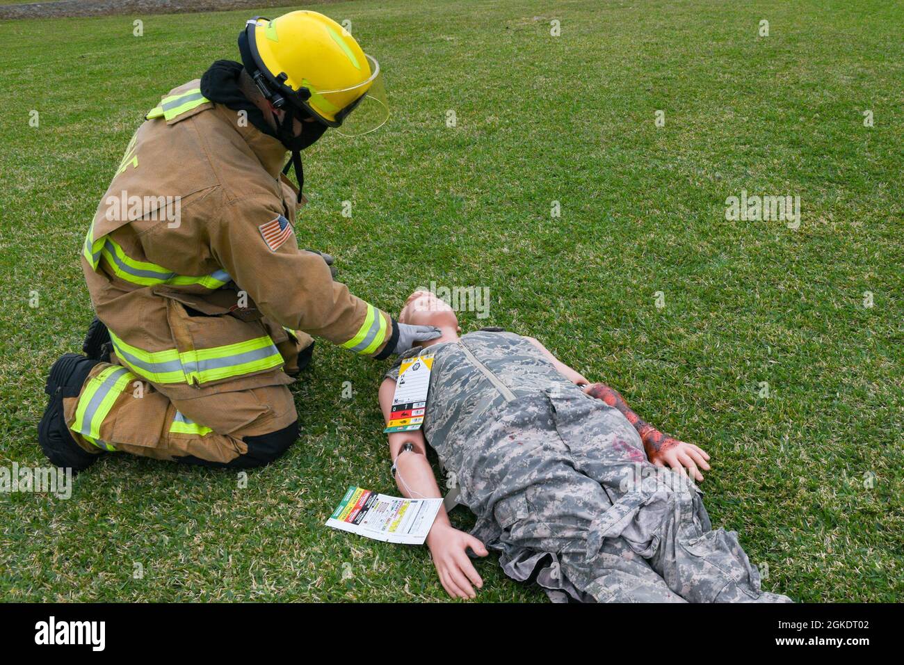 Ein Feuerwehrmann der US-Luftwaffe aus der 18. Civil Engineer Group überprüft den Puls eines simulierten Patienten, der während einer schweren Übung zur Reaktion auf Unfälle auf der Kadena Air Base, Japan, am 24. März 2021 nach einem simulierten Flugzeugunglück geborgen wurde. Bei der Übung wurden die Bereitschaft und Reaktionsfähigkeit des 18. Flügels getestet. Stockfoto