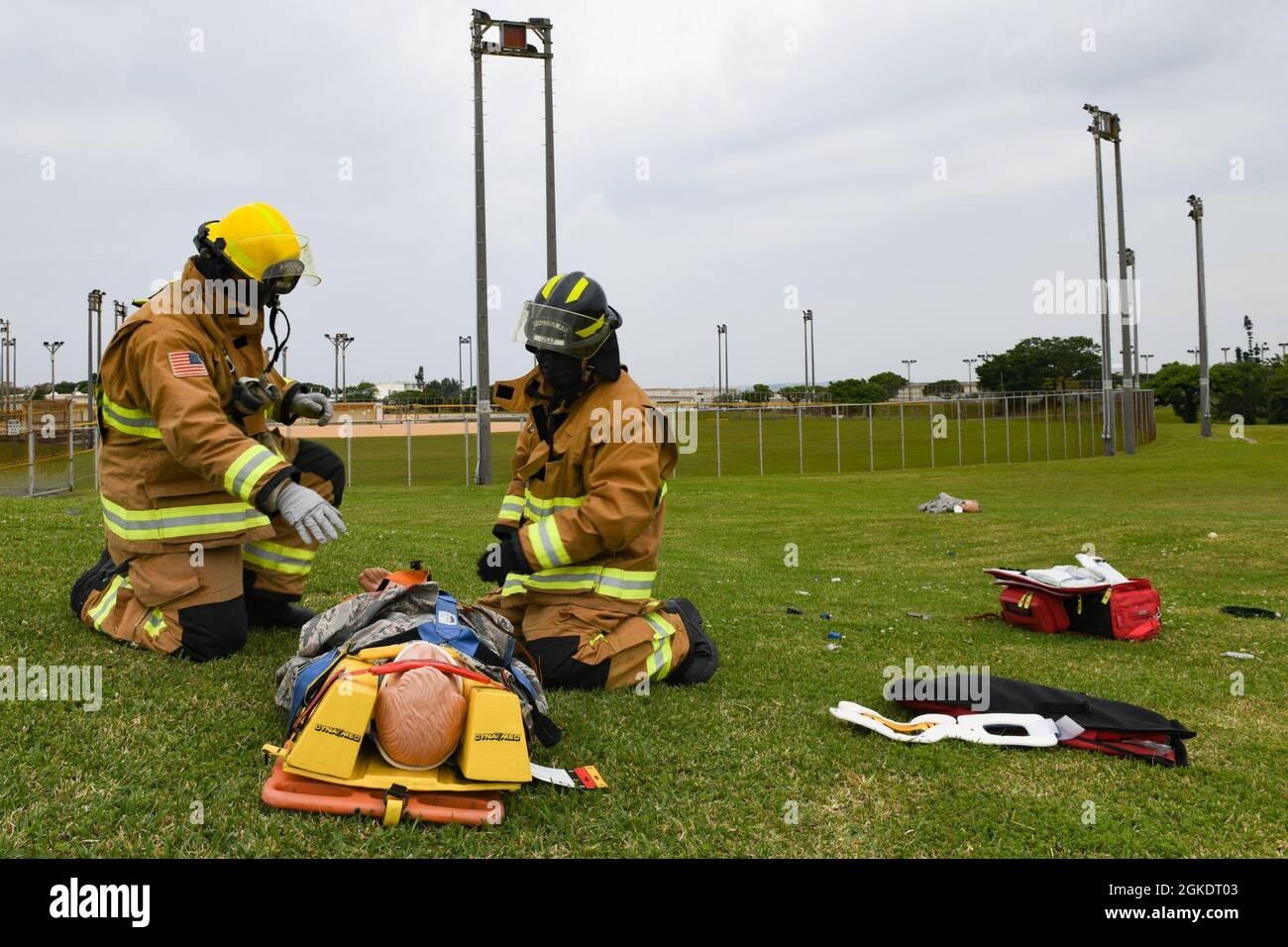 Feuerwehrleute der US-Luftwaffe der 18. Civil Engineer Group beurteilen einen simulierten Patienten, der während einer größeren Übung zur Reaktion auf Unfälle auf dem Luftwaffenstützpunkt Kadena, Japan, nach einem simulierten Flugzeugunglück geborgen wurde, 24. März 2021. Bei der Übung wurden die Bereitschaft und Reaktionsfähigkeit des 18. Flügels getestet. Stockfoto