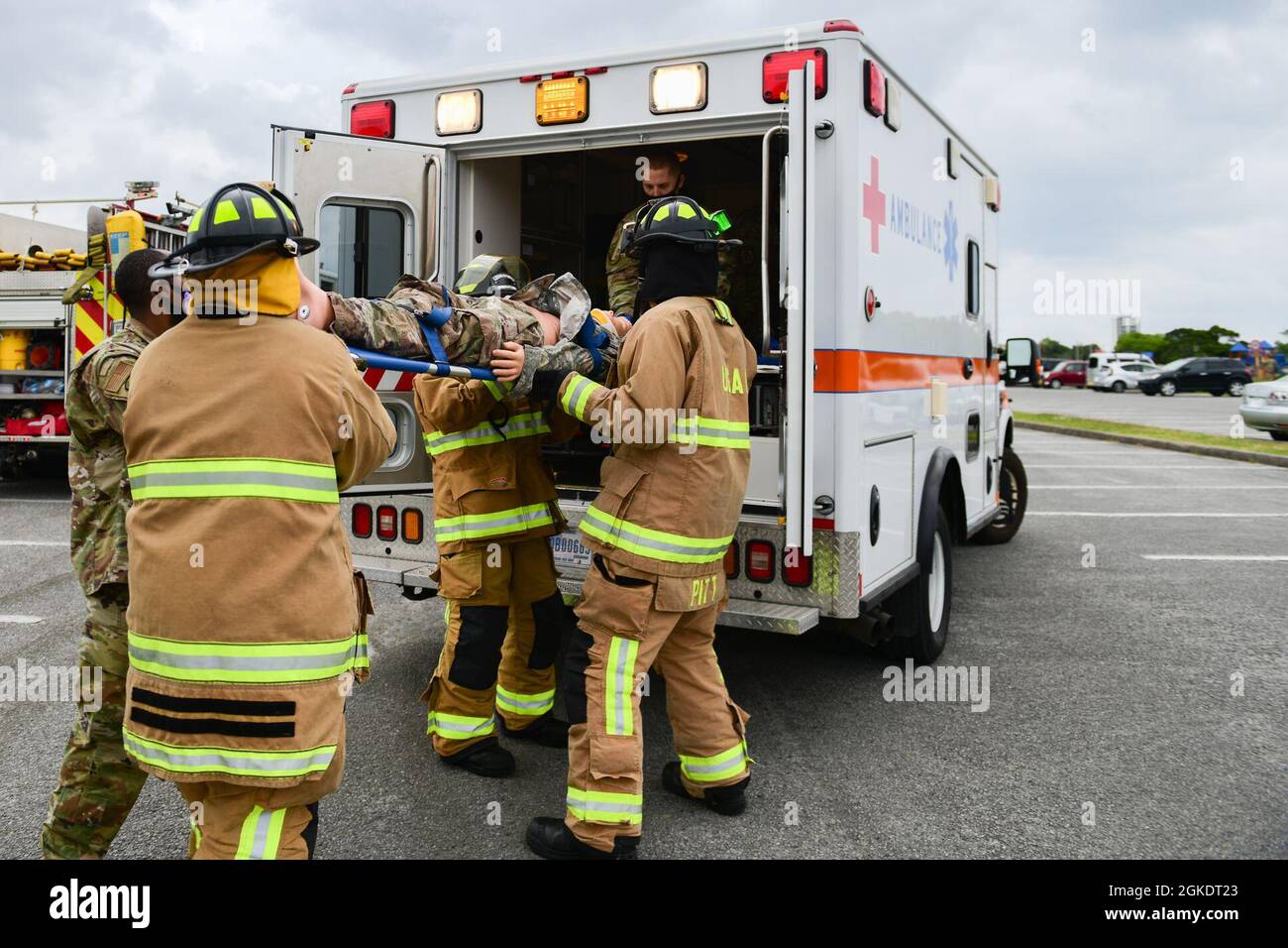 Feuerwehrleute der US-Luftwaffe und medizinisches Personal der 18. Civil Engineer Group und der 18. Medical Group laden während einer großen Übung zur Reaktion auf Unfälle auf dem Luftwaffenstützpunkt Kadena, Japan, am 24. März 2021 eine Schaufensterpuppe in einen Krankenwagen. Bei der Übung wurden die Bereitschaft und Reaktionsfähigkeit des 18. Flügels getestet. Stockfoto