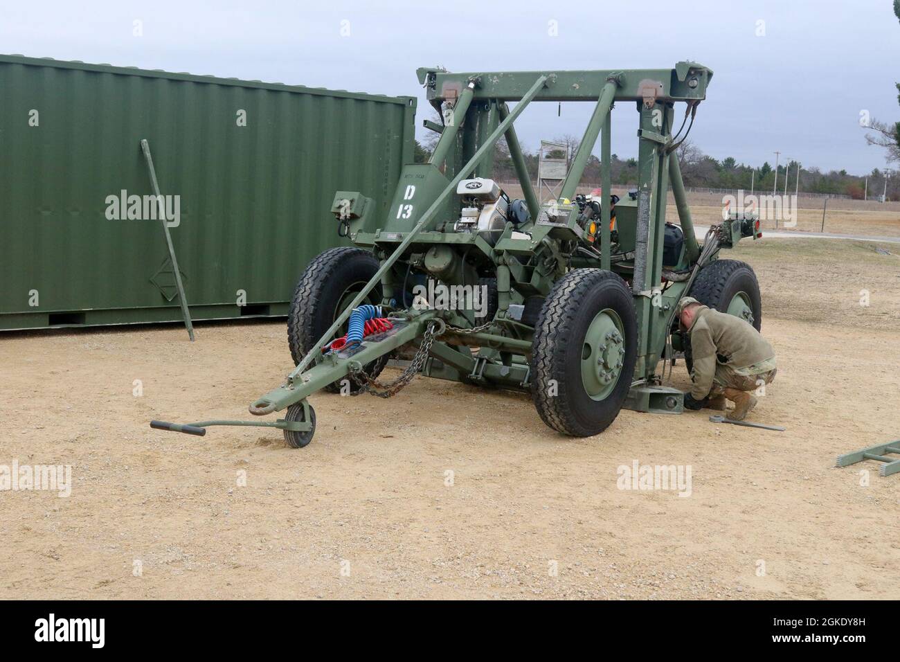 Army Reserve Spc. Mitchel Frasher, zusammen mit dem 311. Field Hospital, passt die Schrauben an das Dolly-System an, während er in Fort McCoy, Wis., Regional Training Site-Medical, trainiert., 25. März 2021. Soldaten nutzen das Dolly-System, um große Behälter voller Krankenhausausrüstung im Rahmen des Aufbaus von Feldlazaretten in kargen Umgebungen zu bewegen. Stockfoto