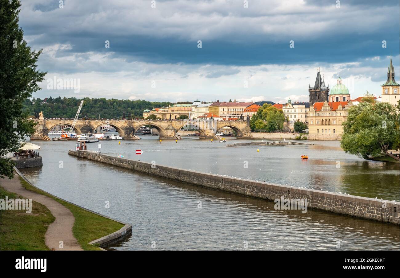 Prag, Tschechische Republik. Blick über den Fluss Vlatava mit der berühmten Karlsbrücke und dem Altstädter Brückenturm in der Ferne. Stockfoto