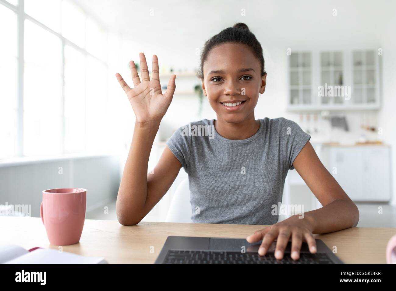 Lächelnde Jugendliche afro amerikanische Mädchen Student zu Hause mit  Laptop studieren, online anrufen und winken Hand zur Webcam Stockfotografie  - Alamy