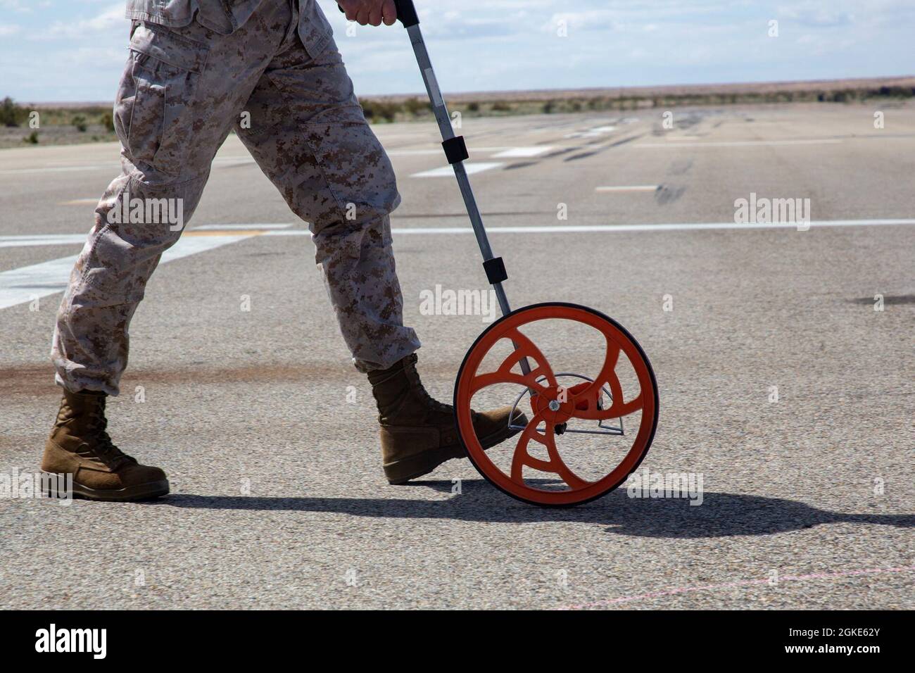 Eine US-Marine mit Aviation Ground Support, Marine Aviation Weapons and Tactics Squadron One (MAWTS-1), misst während einer Basic Recovery After Attack (BRAAT)-Mission eine simulierte Spritze auf der Startbahn, um notwendige Reparaturen für einen fiktiv beschädigten Flugplatz während des Waffen- und Taktiken-Instruktor-Kurses (WTI) 2-21 zu ermitteln, Am Auxiliary Airfield II, in der Nähe von Yuma, Arizona, 26. März 2021. Der WTI-Kurs ist eine siebenwöchige Schulungsveranstaltung, die von MAWTS-1 veranstaltet wird und standardisierte fortgeschrittene taktische Schulungen und die Zertifizierung von Instruktorqualifikationen für Einheiten zur Unterstützung der Marineluftfahrt bietet Stockfoto