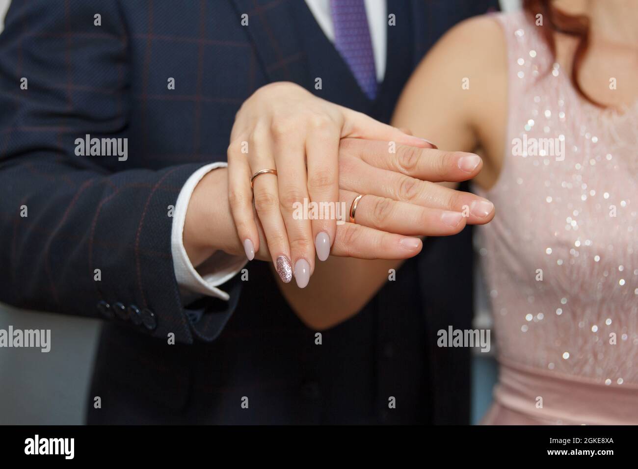 Hände von frisch vermählten Ehepaten, die in Eheringe verliebt sind Stockfoto