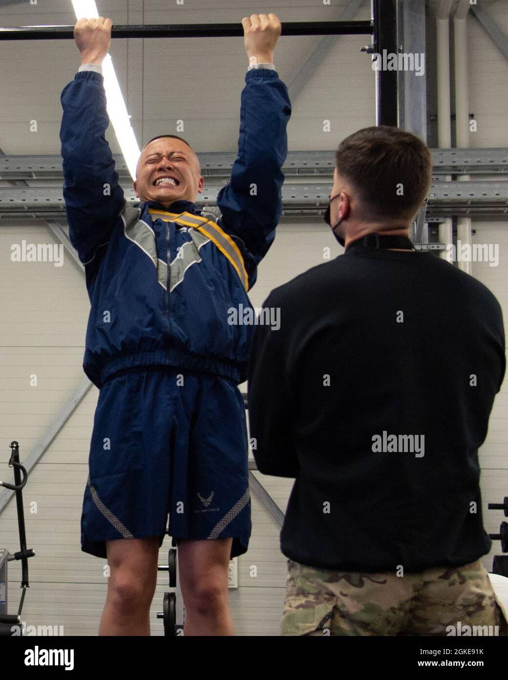 U.S. Air Force Master Sgt. Gavin Saiz, Leiter des Fluges der 435. Sicherheitsstreitkräfte, rechts, beobachtet den U.S. Air Force Master Sgt. Jin Lau, Logistikplaner der 435. Kontingenzgruppe, links, führt während des Kurses Ranger Assessment and Preparation auf der Ramstein Air Base, Deutschland, 27. März 2021 Pull-Ups durch. Mindestens sechs Pull-Ups sind für eine Bewertung erforderlich, die der offiziellen Ranger-Schulprüfung entspricht. Der Kurs Ranger Assessment and Preparation, der vom 435. Air Ground Operations Wing durchgeführt wird, dient dazu, Airm vertraut zu machen Stockfoto