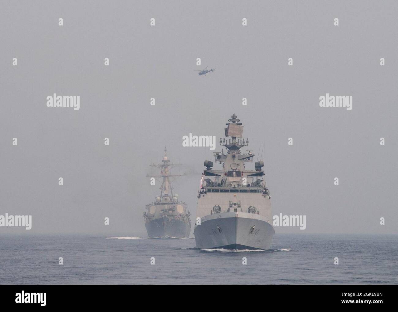 INDISCHER OZEAN (28. März 2021) die indische Navy Shivalik-Klasse Fregatte mit Lenkraketen IN SHIVALIK (F47), Front, Transite in Formation mit dem Arleigh Burke-Klasse Lenkraketen-Zerstörer USS Russell (DDG 59) während einer gemeinsamen Seeübung am 28. März 2021. Russell, Teil der Theodore Roosevelt Carrier Strike Group, ist im geplanten Einsatzgebiet der 7. US-Flotte. Als größte vorwärtseingesetzte Flotte der US-Marine operiert und interagiert die 7. Flotte routinemäßig mit 35 maritimen Nationen und führt Missionen durch, um eine freie und offene Region im Indo-Pazifik-Raum zu erhalten und zu schützen Stockfoto