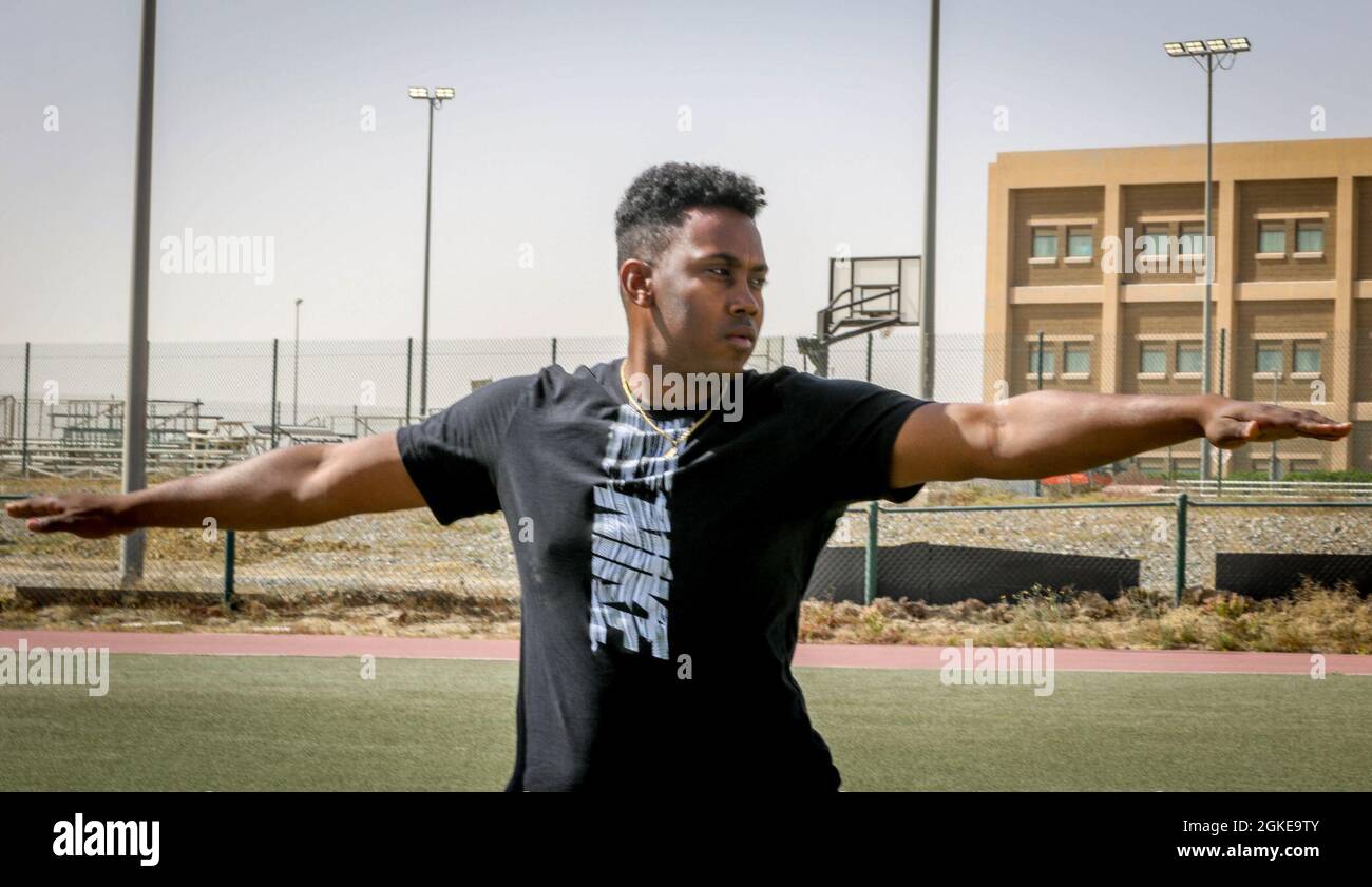 Personal Sgt. Jordan Powell mit der Task Force Spartan und der 36. Infanterie-Division führt die Hatha Yoga, Warrior Pose, im Camp Arifjan, Kuwait, März 28, 2021. Laut einem Artikel des International Journal of Yoga, der am 2020. Mai veröffentlicht wurde, „zeigten die Studienergebnisse, dass yogische Praktiken die Muskelkraft und die Körperflexibilität erhöhen, die Atemwegs- und Herz-Kreislauf-Funktion fördern und verbessern, die Genesung und Behandlung von sucht fördern, Stress, Angst, Depression und chronische Schmerzen reduzieren, Verbessern Sie die Schlafmuster und verbessern Sie das allgemeine Wohlbefinden und die Lebensqualität.“ Stockfoto