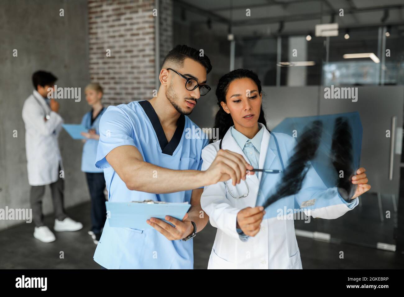 Zwei junge Ärzte betrachten Röntgenaufnahmen Stockfoto