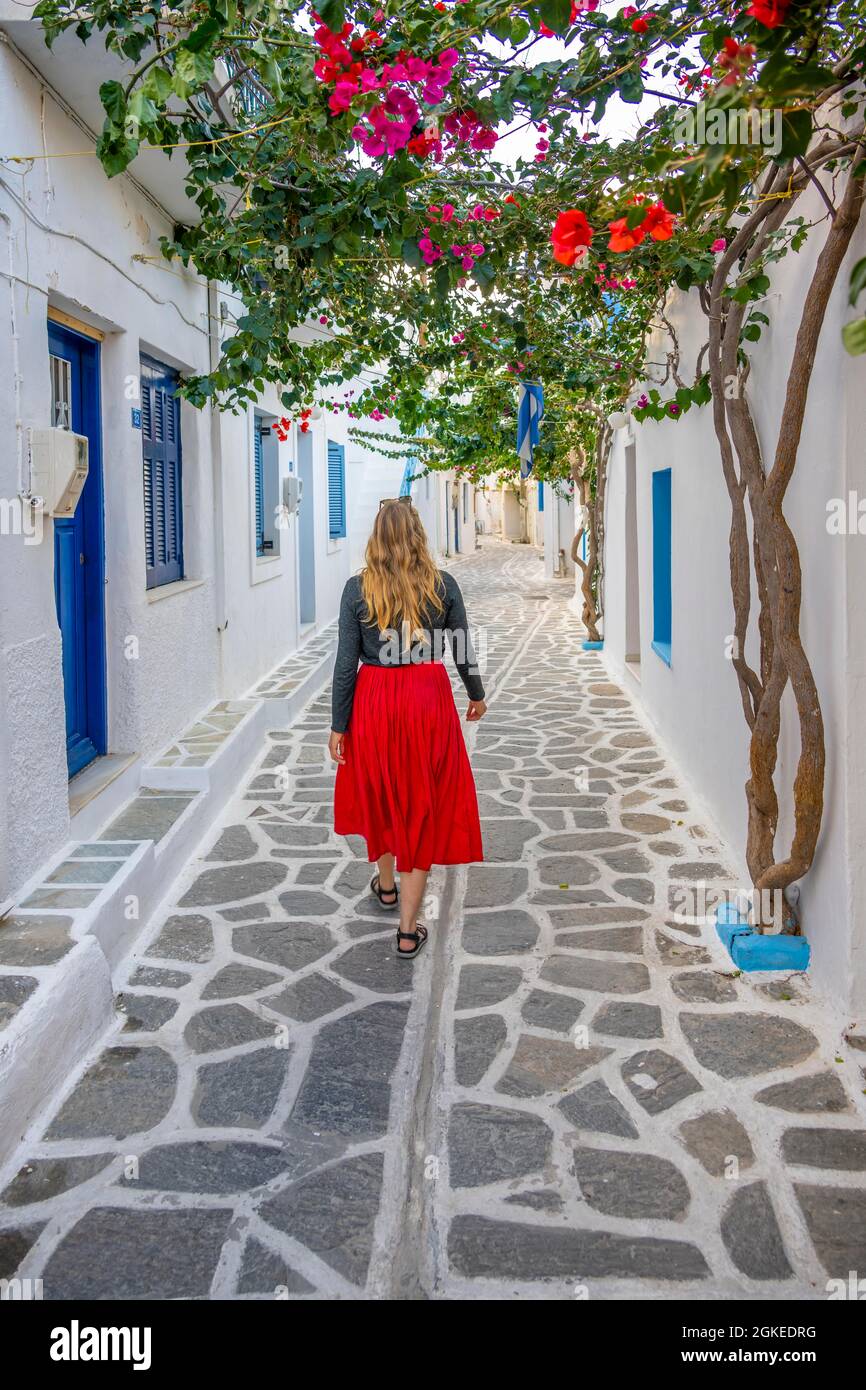 Junge Frau mit Kleid zu Fuß durch Gasse mit kykladischen Häusern, Altstadt von Parikia, Paros, Kykladen, Griechenland Stockfoto