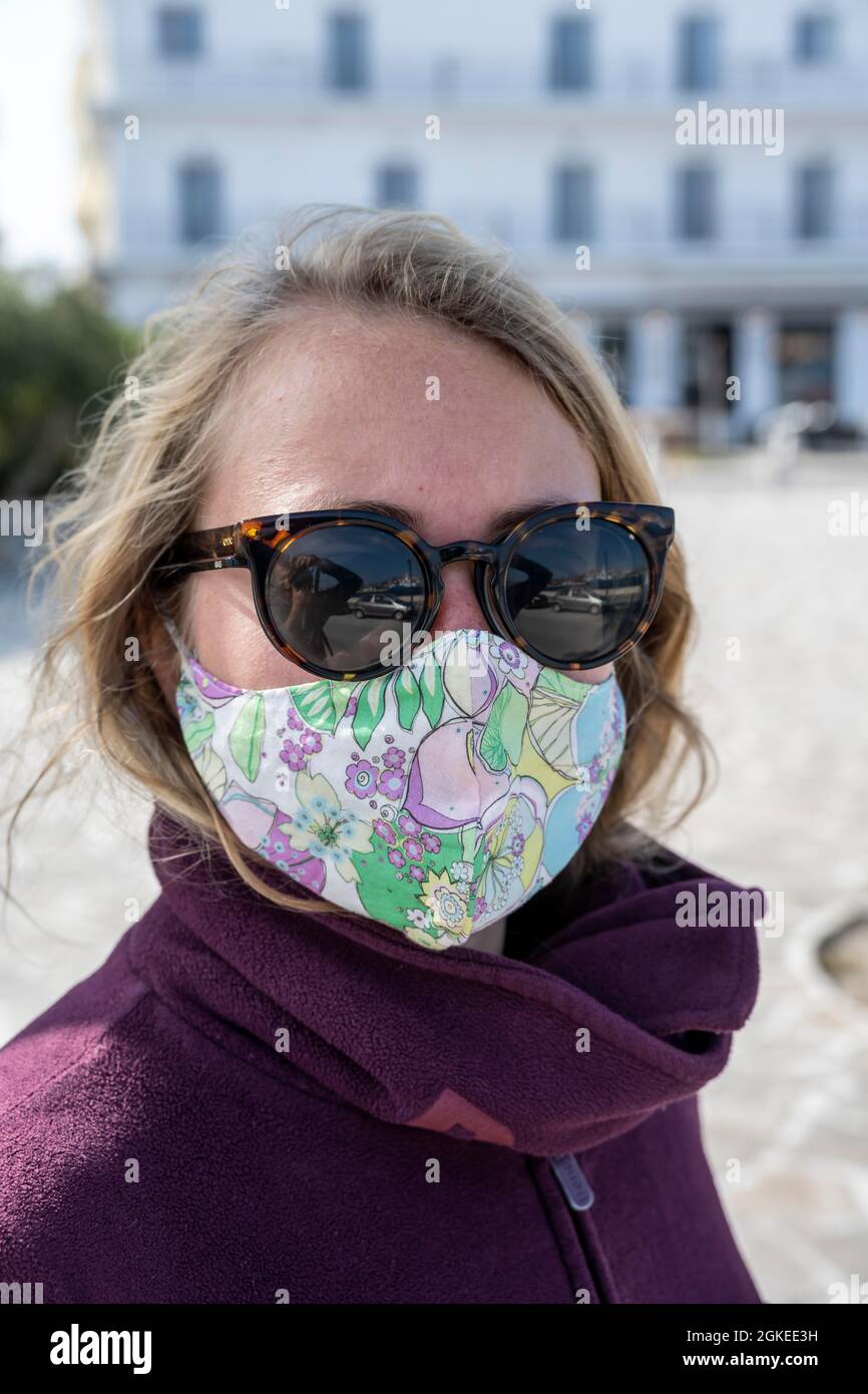 Junge Frau im Urlaub mit Mund-zu-Nase-Abdeckung, Maske vs. Corona, griechenland Stockfoto