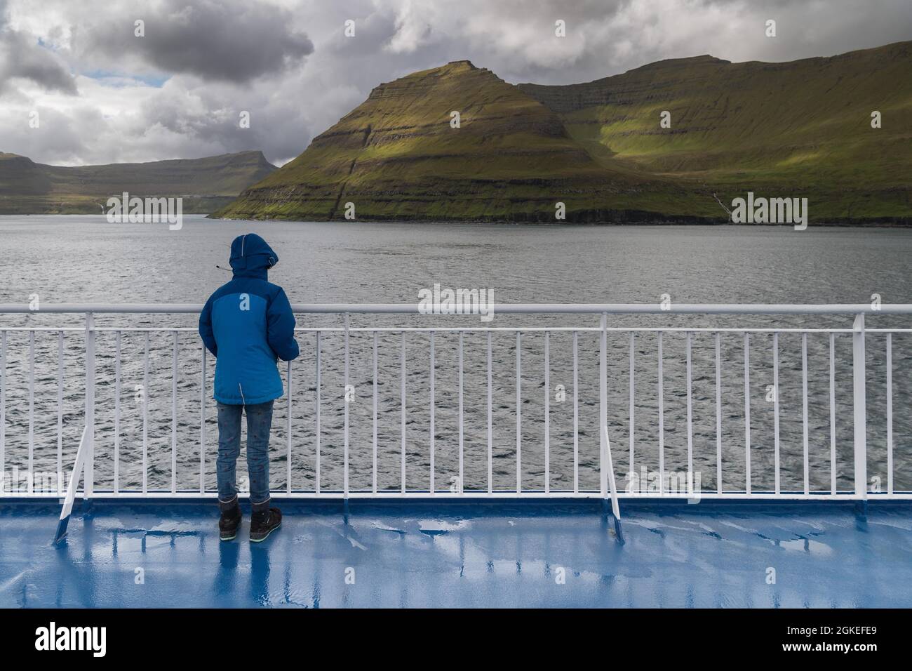 Mädchen, das an der Reling der Fähre Norroena, Smyril Line Schiff, während der Passage durch die Färöer Inseln, Färöer Inseln, Dänemark Stockfoto