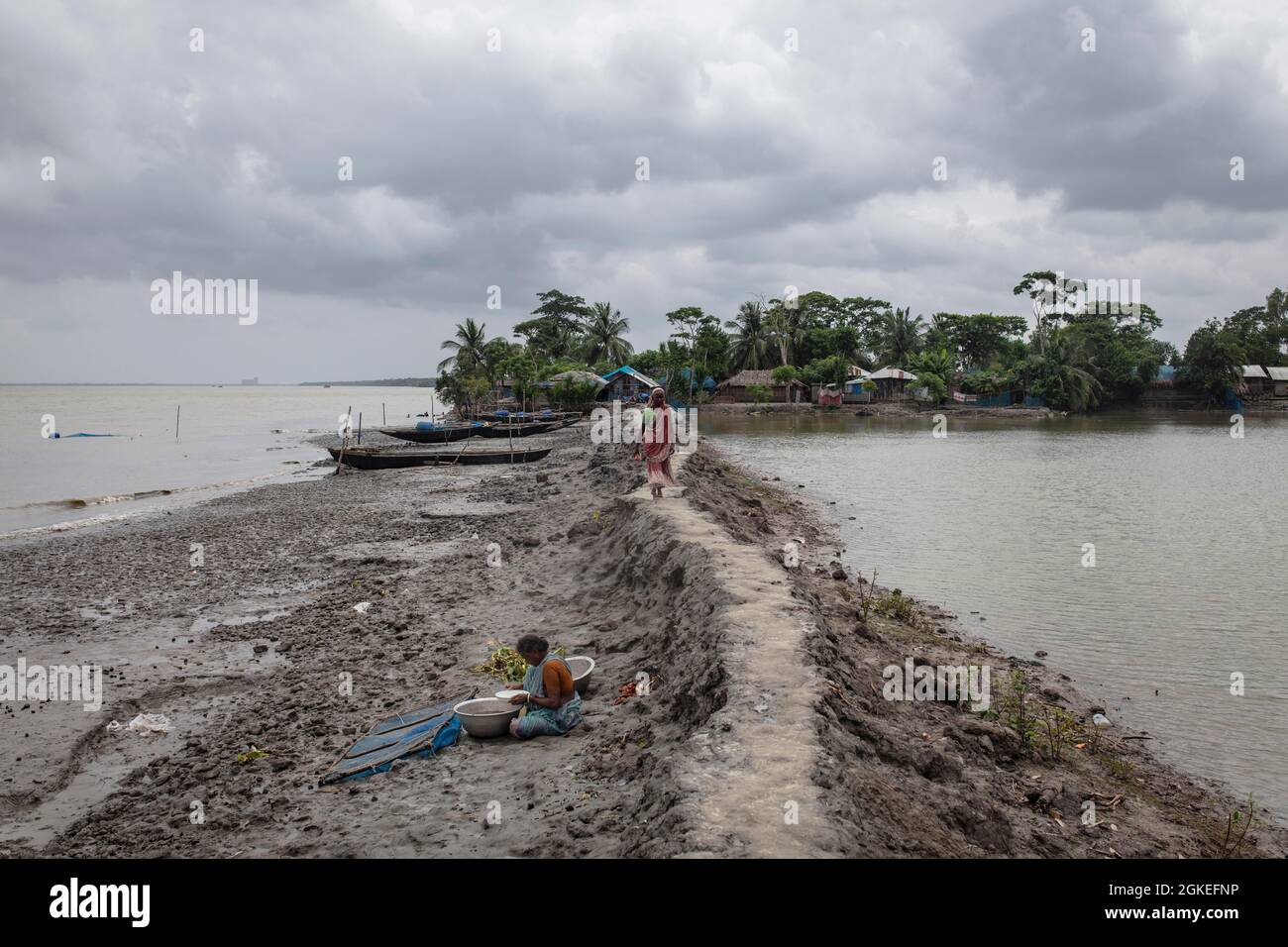 Frau, die auf einem schlammigen Damm auf der Halbinsel Banishanta, Mongla, Sundarbans, Bangladesch, läuft Stockfoto