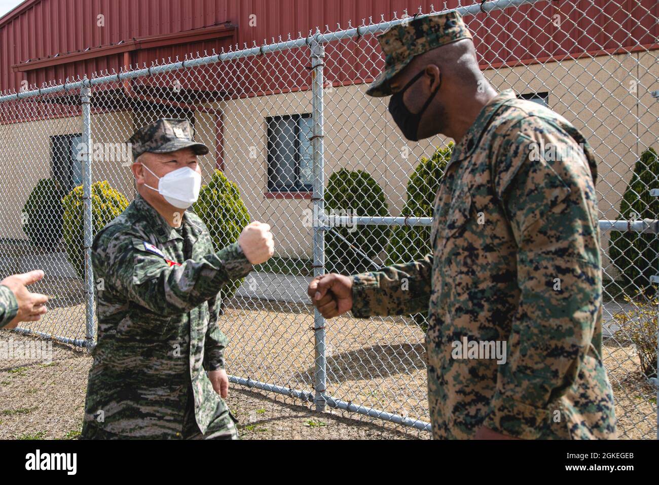 Marine Corps (ROKMC), Republik Korea, Sgt. Maj. Hee Joong Cho, links, der 1. Feldwebel der ROK Marine Division, begrüßt die US Marine Corps Sgt. Maj. Wesley O. Turner II, rechts, der Hauptfeldwebel des Lagers Mujuk, vor dem Hauptquartier des Lagers Mujuk, Lager Mujuk, Republik Korea, 30. März 2021. Hochrangige Vertreter des Kommandos des Sondersicherheitsbereichs Pohang besuchten das Lager Mujuk, um sich mit dem Hauptfeldwebel des Lagers zu treffen und die Installation des Marine Corps zu besichtigen. Stockfoto