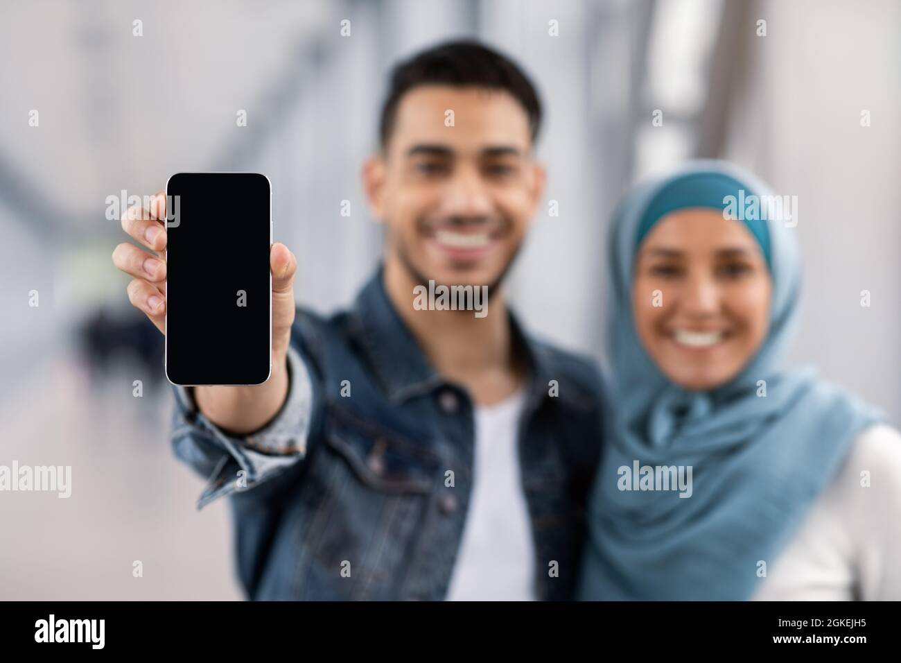 Beat Anw Fröhliches Islamisches Paar Zeigt Smartphone Mit Schwarzem Bildschirm An Der Kamera Stockfoto