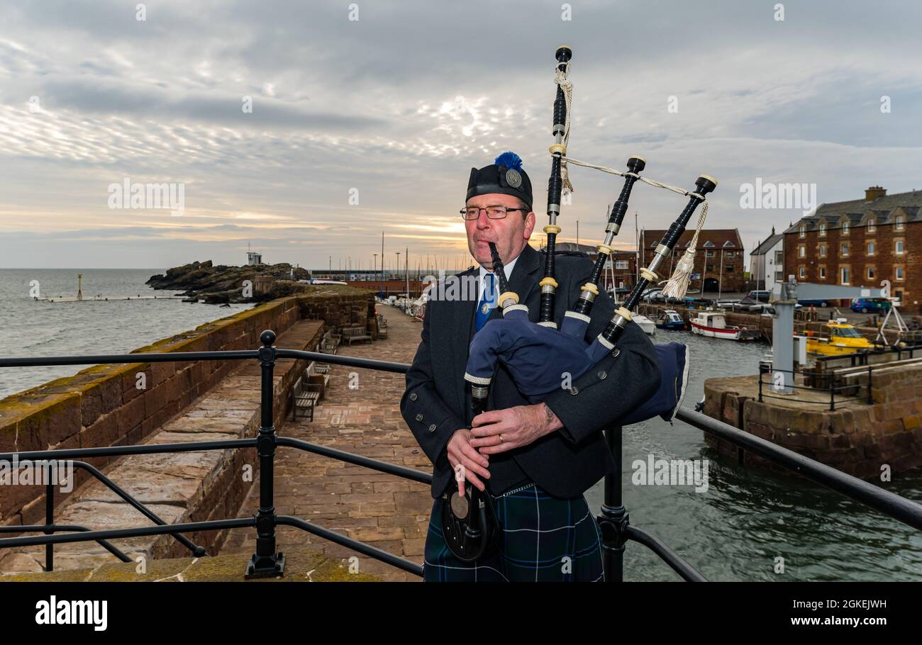 Piper spielt Dudelsäcke im Morgengrauen zum Gedenken an den St. Valery Day (schottische Soldaten wurden im 2. Weltkrieg gefangen genommen), North Berwick Harbour, East Lothian, Schottland, Großbritannien Stockfoto