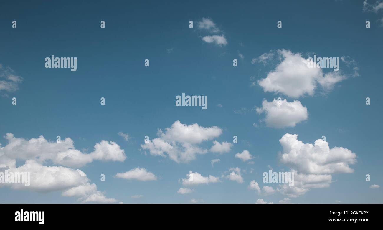 Blauer Himmel mit weißen, flauschigen Wolken am Mittag Stockfoto