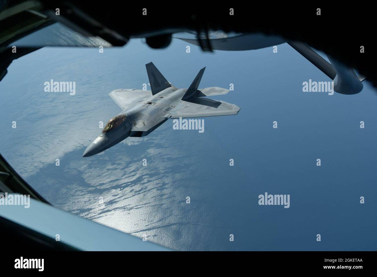 Ein F-22 Raptor der US-Luftwaffe aus der 199. Kampfschürze, die der Joint Base Pearl Harbor-Hickam, Hi., zugewiesen wurde, biegt nach der Betankung am 1. April 2021 auf die Seite eines KC-135 Stratotankers der 909. Lufttankschwadron der japanischen Kadena Air Base. Das 199. Jagdgeschwader wurde zur Marine Corps Air Station Iwakuni, Japan, eingesetzt, um im Rahmen des dynamischen Einsatzkonzepts des US-Indo-Pacific Command eine integrierte Ausbildung mit Marine- und Marinestreitkräften durchzuführen. Stockfoto