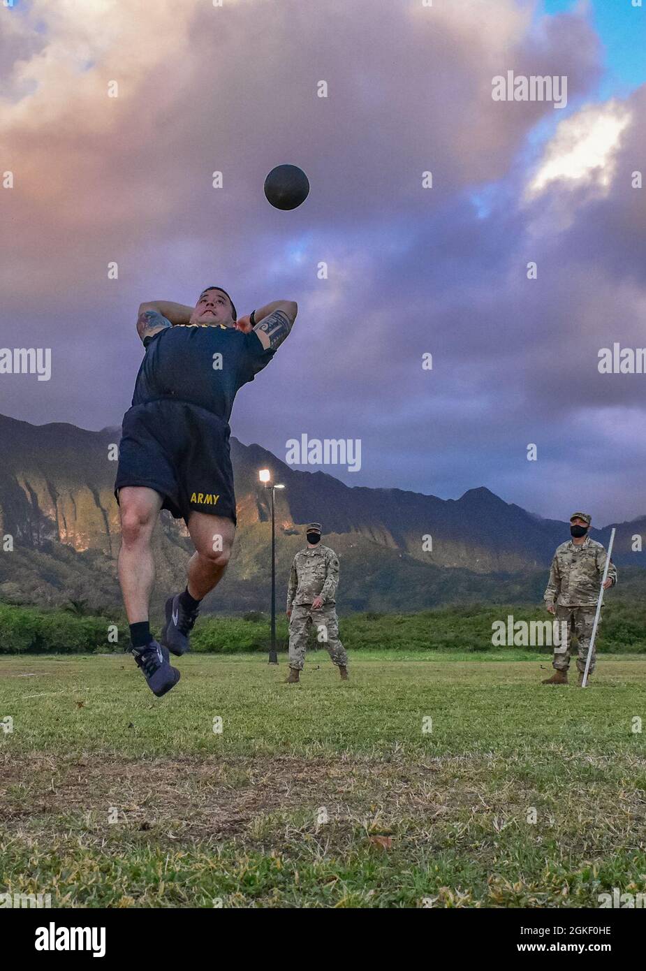 Hawaii Army National Guard Soldier, Chief Warrant Officer 3 Anthony Peck, ein UH-60M Black Hawk Helikopter Pilot mit Ablösung 1, Golf Company, 1. Bataillon, 189. Aviation Regiment, 103. Truppenkommando bekommt etwas Luft während der Durchführung der stehenden Power Throw (SPT) Veranstaltung während des Army Combat Fitness Test, Waimanalo, Hawaii, 2. April 2021. Der SPT misst die Sprengkraft, Flexibilität und dynamische Balance des oberen und unteren Körpers und unterstützt dabei Aufgaben wie das Ziehen eines Freundes, das Werfen einer Handgranate und den Einsatz progressiver Kräfte bei Mensch-zu-Mann-Kontakt. Die Beurteilung der Bereitschaft für sechs Ereignisse, ACFT Stockfoto