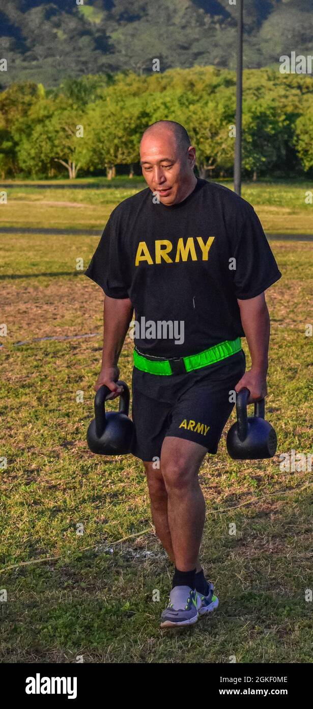 Soldat Der Nationalgarde Der Hawaii-Armee, Sgt. 1st Class Matthew Mitsui, A Flight Medic with Detachment 1, Golf Company, 1st Battalion, 189th Aviation Regiment, 103rd Truppe Command trägt im Rahmen des Sprint-Drag-Carry (SDC)-Events während des Army Combat Fitness Tests, Waimanalo, Hawaii, 2. April 2021, Kettelglocken. Die DEZA misst die Sprengkraft, die Flexibilität und das dynamische Gleichgewicht des Oberkörpers und des Unterkörpers und unterstützt dabei Aufgaben wie das Ziehen eines Freundes, das Werfen einer Handgranate und den Einsatz progressiver Kräfte bei Mensch-zu-Mann-Kontakt. Die Beurteilung der Bereitschaft für sechs Ereignisse, ACFT, soll den Cu ersetzen Stockfoto