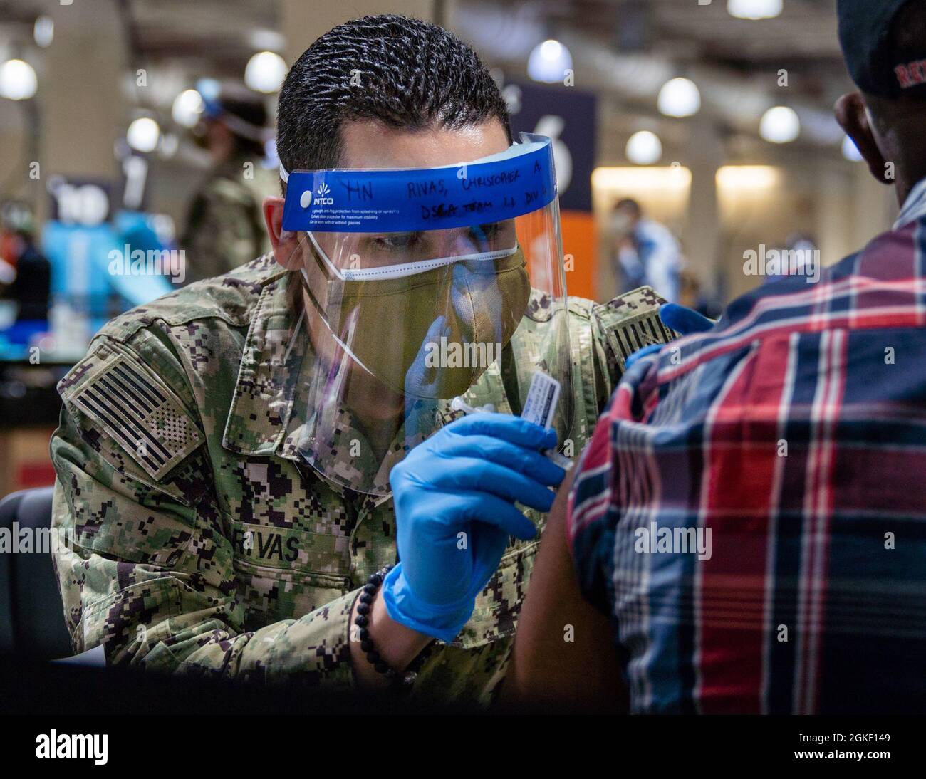 Christopher Rivas, gebürtiger Boston, der dem Naval Medical Center Portsmouth, Virginia, zugewiesen wurde, verabreicht einem lokalen Gemeindemitglied im Hynes Convention Center COVID-19 Community Vaccine Center in Boston, 2. April 2021, einen COVID-19-Impfstoff. Seeleute der US-Marine aus dem ganzen Land werden zur Unterstützung der Impfeinsätze des Verteidigungsministeriums eingesetzt. Das U.S. Northern Command setzt sich über die U.S. Army North weiterhin dafür ein, die Federal Emergency Management Agency im Rahmen des „Whole-of-gove“ kontinuierlich und flexibel durch das Verteidigungsministerium zu unterstützen Stockfoto