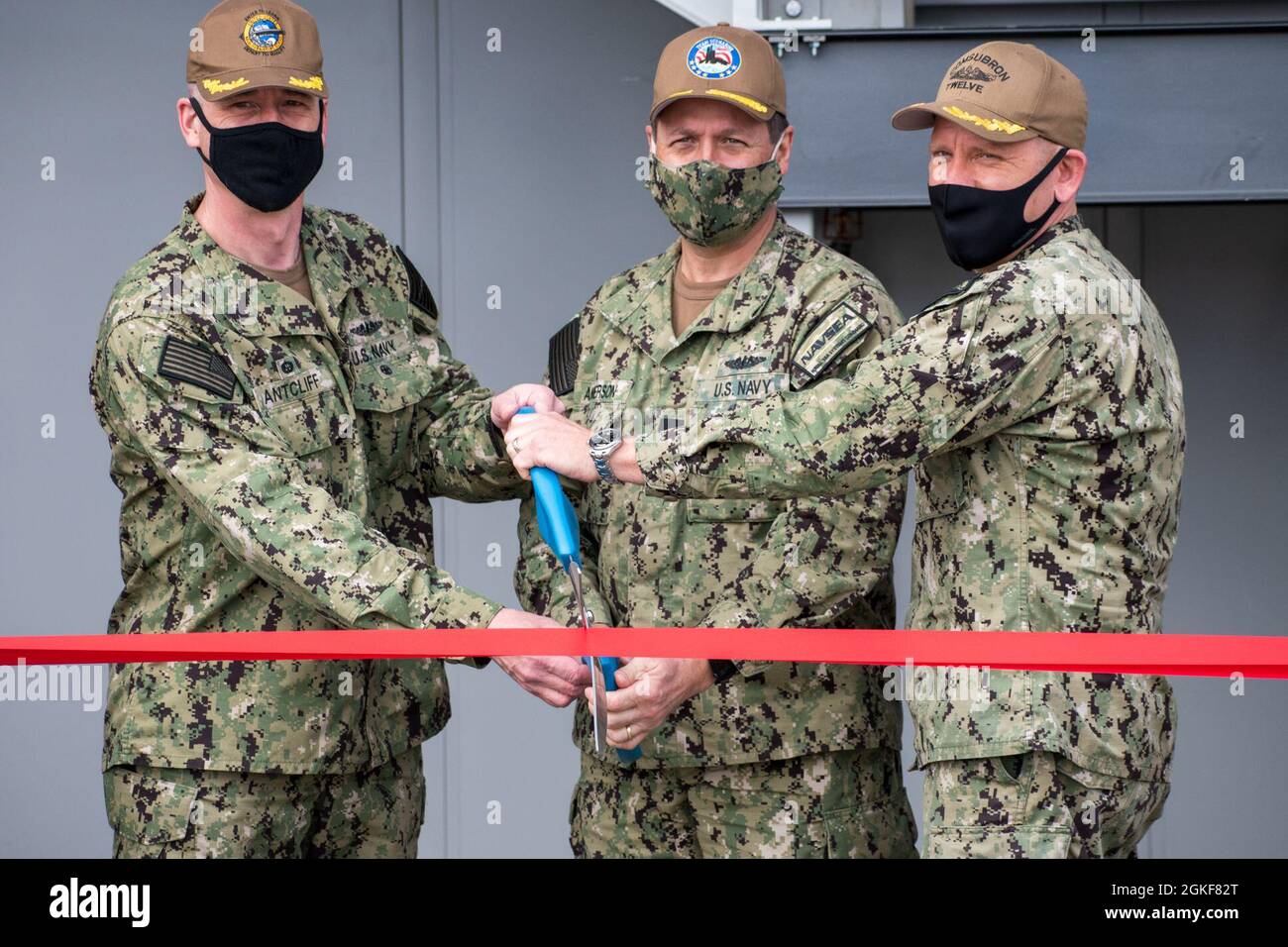 Admiral Edward L. Anderson, stellvertretender Kommandeur – Unterseekriege, Naval Sea Systems Command; Stephen B. Fahey, Senior Executive Service, PNS Nuclear Engineering and Planning Manager; Captain Matthew R. Boland, Commodore, Commander Submarine Squadron 12; Captain Daniel W. Ettlich, Commander, Portsmouth Naval Shipyard; Und Kapitän Steven W. Antcliff, Kommandant der Marine Submarine School, Schnitt das Band bei einer Zeremonie, bei der die Eröffnung der neuesten Abteilung der Naval Submarine School auf der Portsmouth Naval Shipyard in Kittery, Maine, am 7. April 2021 gefeiert wurde. Dieses innovative Training Stockfoto