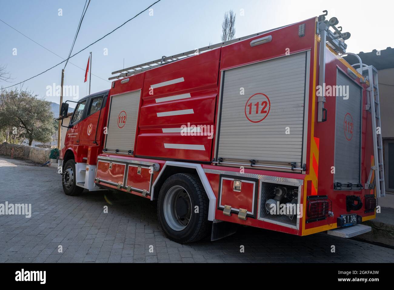 Seferihisar, Izmir, Türkei - 03.09.2021: Seitenansicht des roten traditionellen Feuerwehrmotors, der vor der örtlichen Feuerwehr geparkt ist Stockfoto