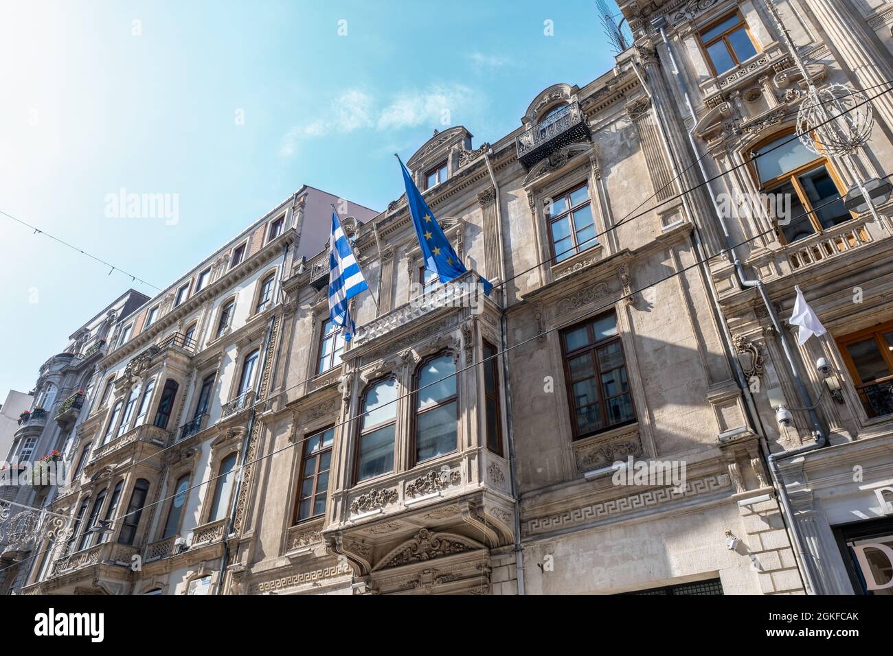 Taksim, Istanbul, Türkei - 03.12.2021: Low-Angle-Ansicht der griechischen und EU-Flaggen auf dem historischen Gebäude des griechischen Generalkonsulats Istanbul in Stockfoto
