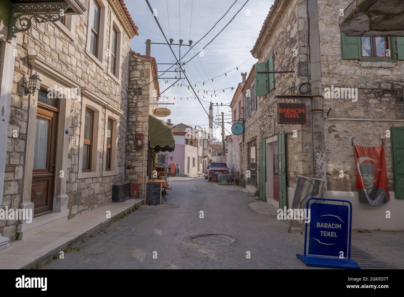 Urla, Izmir, Türkei - 03.08.2021: Historische touristische Straßen- und Steingebäude und Geschäfte an einem bewölkten Tag Stockfoto
