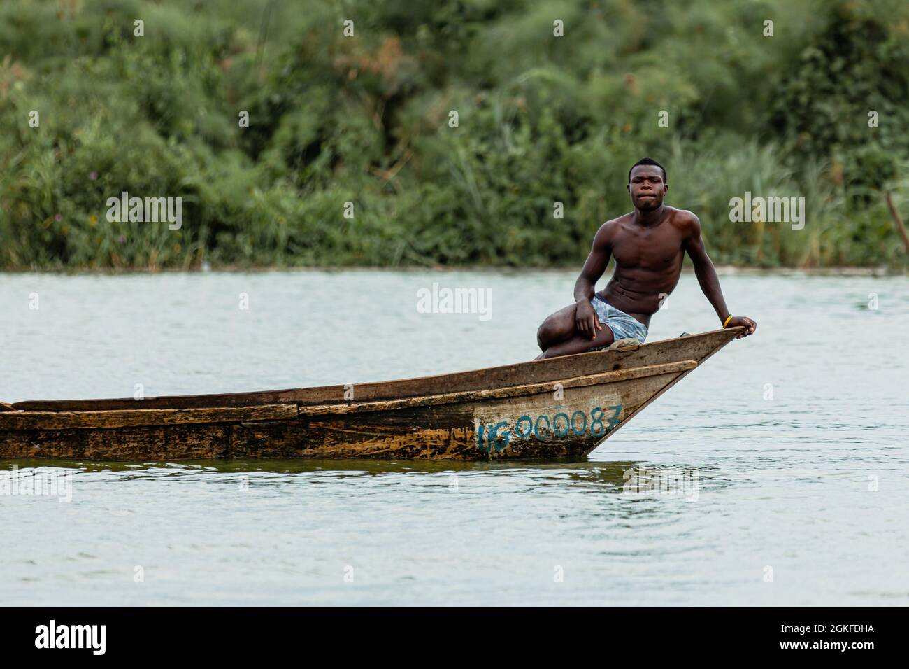 Ein Einheimischer, der am Rand seines Kanus sitzt. Queen Elizabeth National Park, Uganda Stockfoto