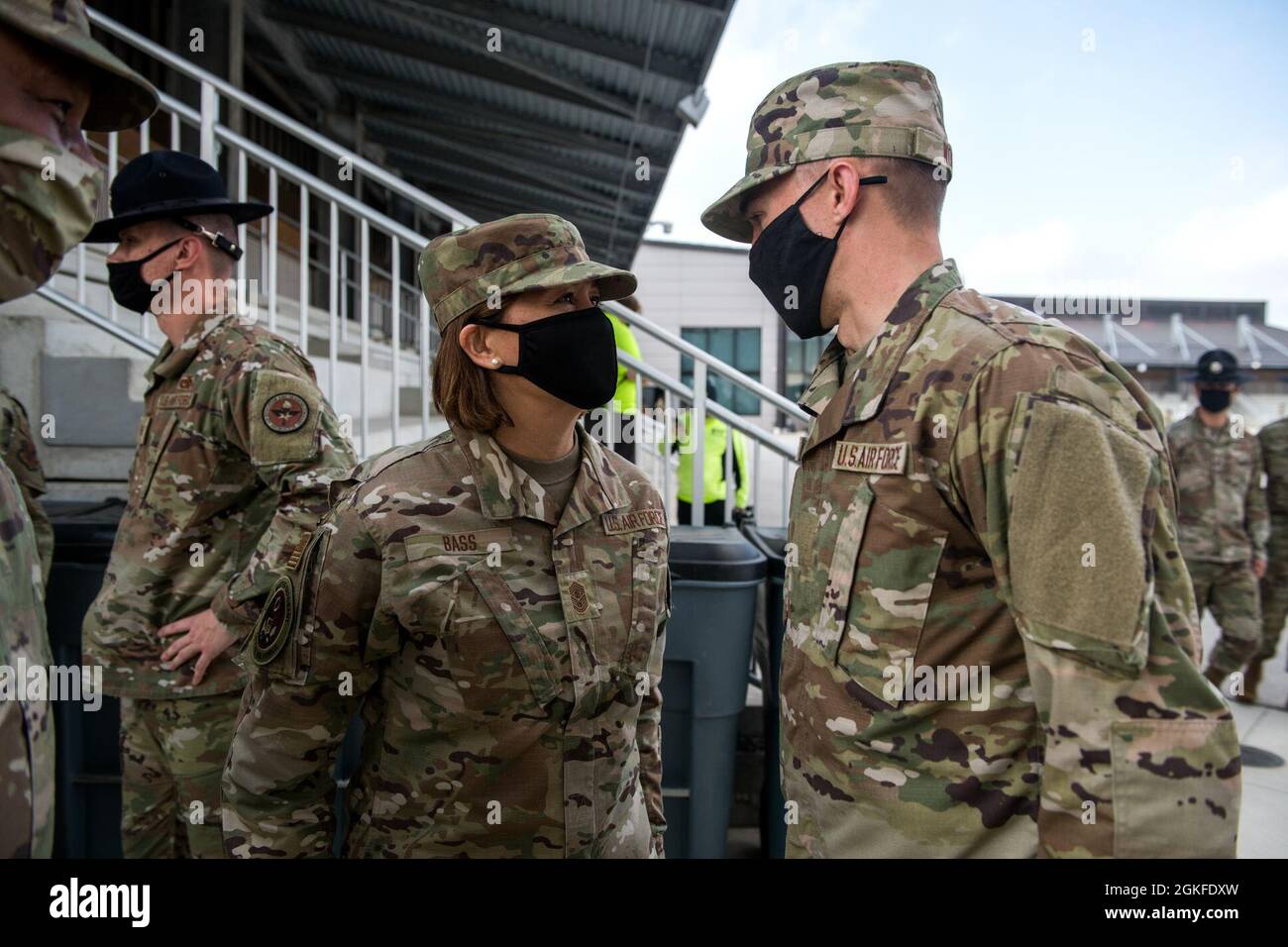 US Air Force Col. Michael S. Newsom (links), Kommandant der 737. Trainingsgruppe und Chief Master Sgt. Von der Luftwaffe Joanne S. Bass (Mitte), gratuliert dem Top Airman (rechts) nach seiner Abschlussfeier für das militärische Grundtraining am 8. April 2021 auf der Joint Base San Antonio-Lackland, Texas. Bass repräsentiert die höchstrangige Führungsebene, und als solche gibt er der angetretenen Kraft die Richtung vor und vertritt ihre Interessen, je nach Bedarf, gegenüber der amerikanischen Öffentlichkeit und jenen auf allen Regierungsebenen. Sie dient als persönliche Berater des Stabschefs und der Sekretärin des A Stockfoto