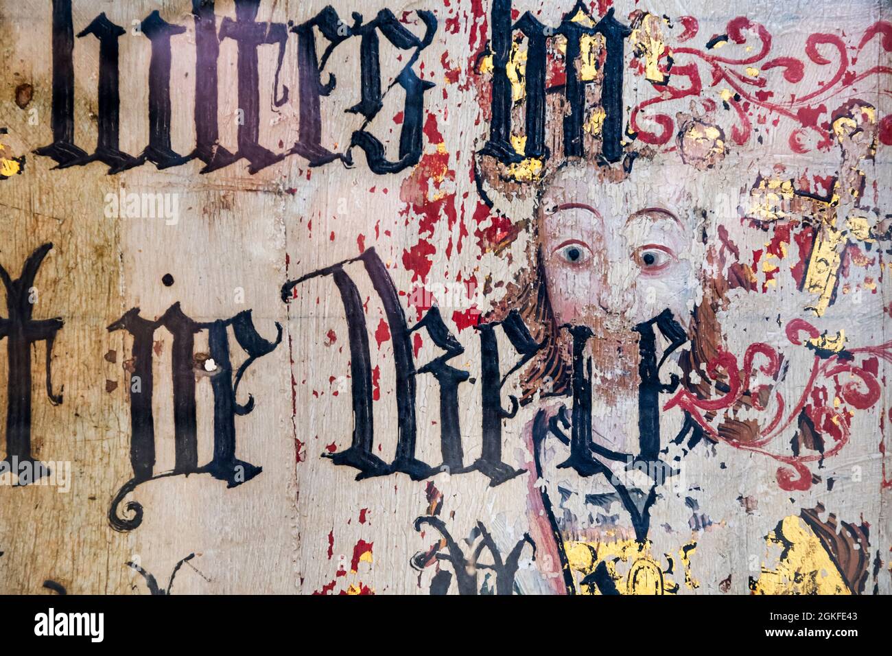 Binham Priory Rood-Bildschirm. Mittelalterliches Gemälde eines unbekannten heiligen, der ein Kreuz hält, das durch einen schwarz-Buchstaben übermalten Text aus Cranmers Bibel von 1539 zeigt. Stockfoto