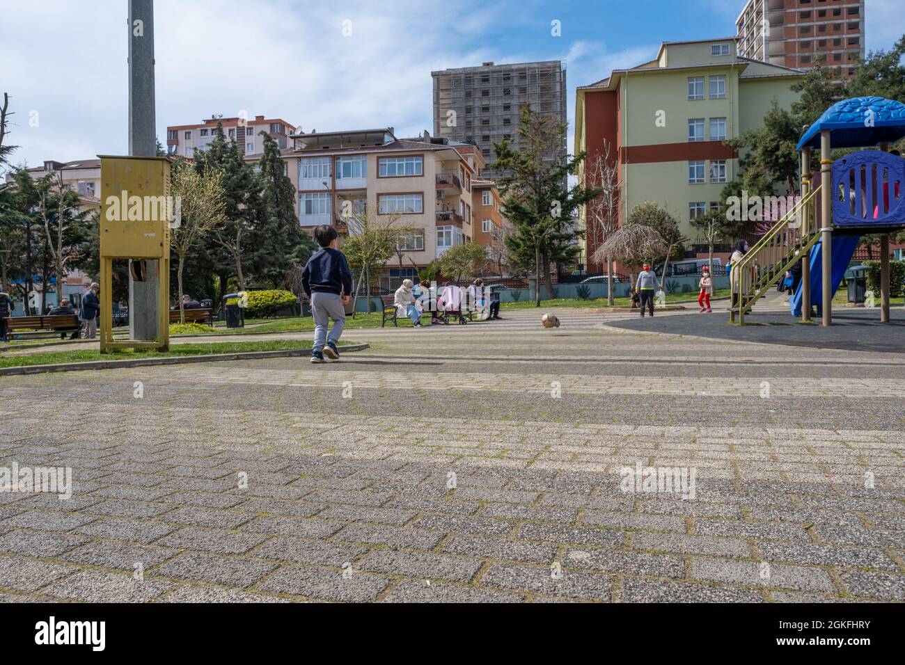 Maltepe, Istanbul, Türkei - 04.13.2021: Zwei Kinder mit Schutzmasken spielen Fußball mit deformierten und zerrissenen Bällen und andere Kinder haben Spaß Stockfoto