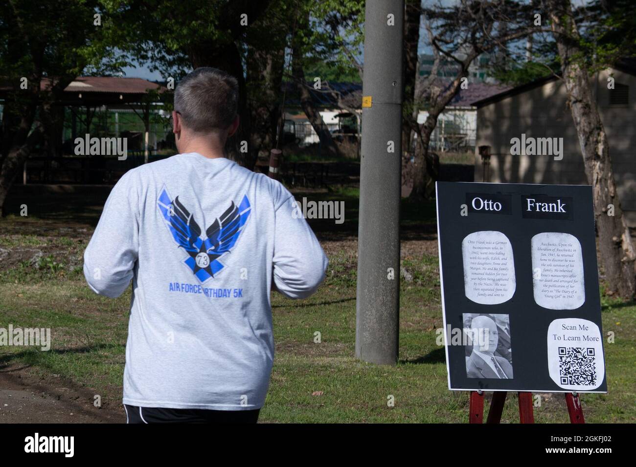 Ein Teilnehmer läuft während der 5 km Holocaust-Gedenkveranstaltung an Otto Franks Ausstellungstafel vorbei und läuft in der Nähe des Par 3 Golfplatzes auf dem Yokota Air Base, Japan, 9. April 2021. Otto Frank war das einzige überlebende Mitglied seiner Familie und veröffentlichte später die Schriften seiner Tochter in „das Tagebuch der Anne Frank“. Stockfoto