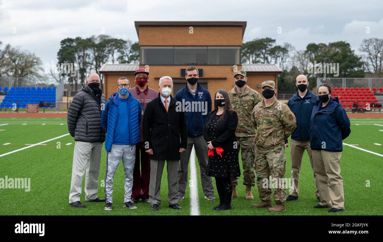 48th Fighter Wing Airmen nehmen an einer Zeremonie zum Schneiden von Bändern mit Mitarbeitern des Verteidigungsministeriums der Royal Air Force Lakenheath, England, am 9. April 2021 Teil. Die Zeremonie wurde durchgeführt, um an die gemeinsamen Bemühungen von DoDEA und dem Air Force Fitness Center bei der Eröffnung der neu gebauten Laufstrecke und des neuen Feldes zu erinnern. Stockfoto