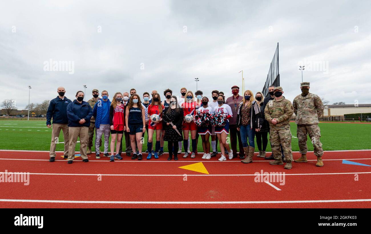 48th Fighter Wing Airmen nehmen an einer Zeremonie zum Schneiden von Bändern mit Mitarbeitern und Studenten des Verteidigungsministeriums Teil, die am 9. April 2021 in der Royal Air Force Lakenheath, England, stattfand. Die Zeremonie wurde durchgeführt, um an die gemeinsamen Bemühungen von DoDEA und dem Air Force Fitness Center bei der Eröffnung der neu gebauten Laufstrecke und des neuen Feldes zu erinnern. Stockfoto