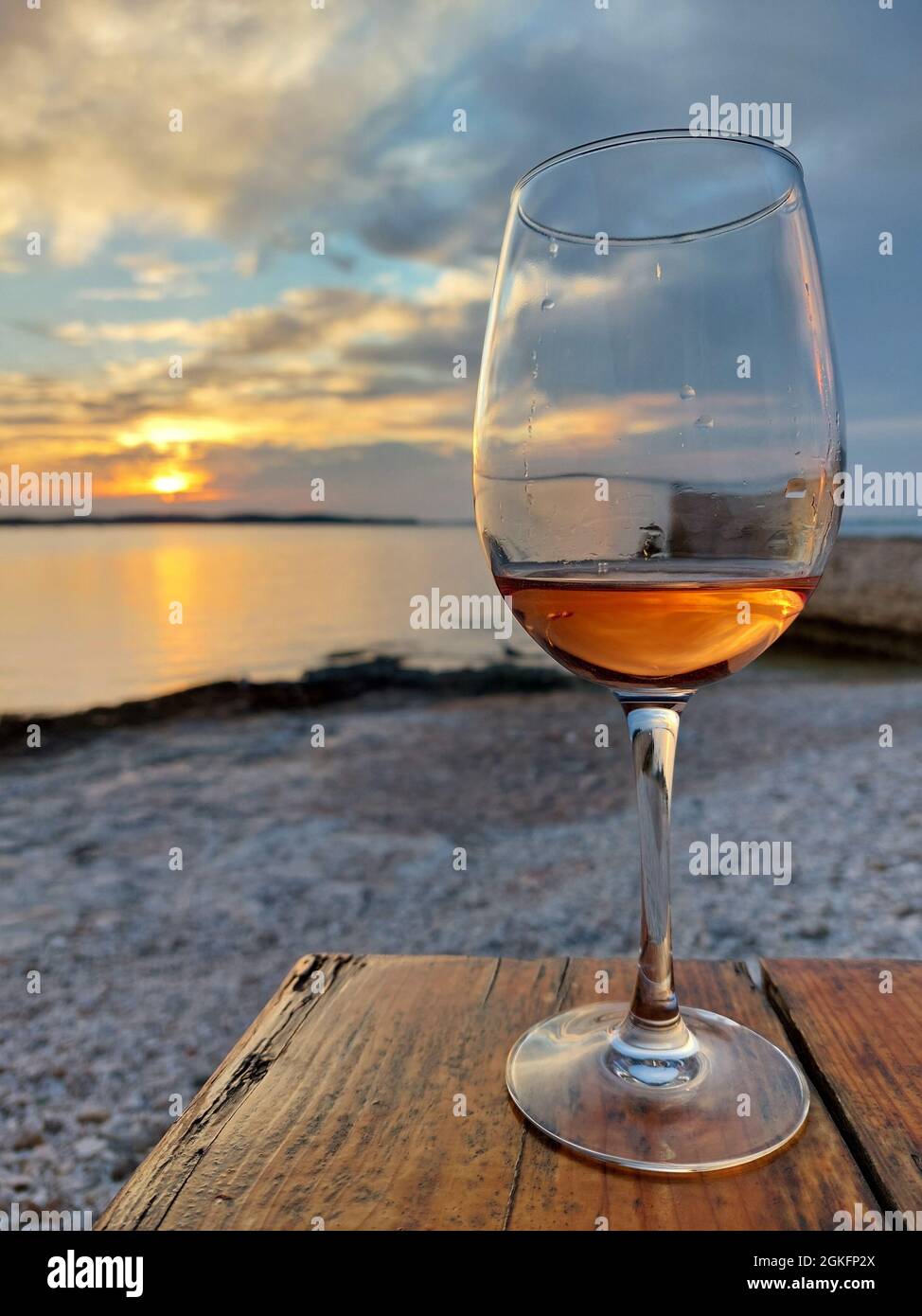 Sonnenuntergang mit einem Glas Wein am Strand Stockfoto