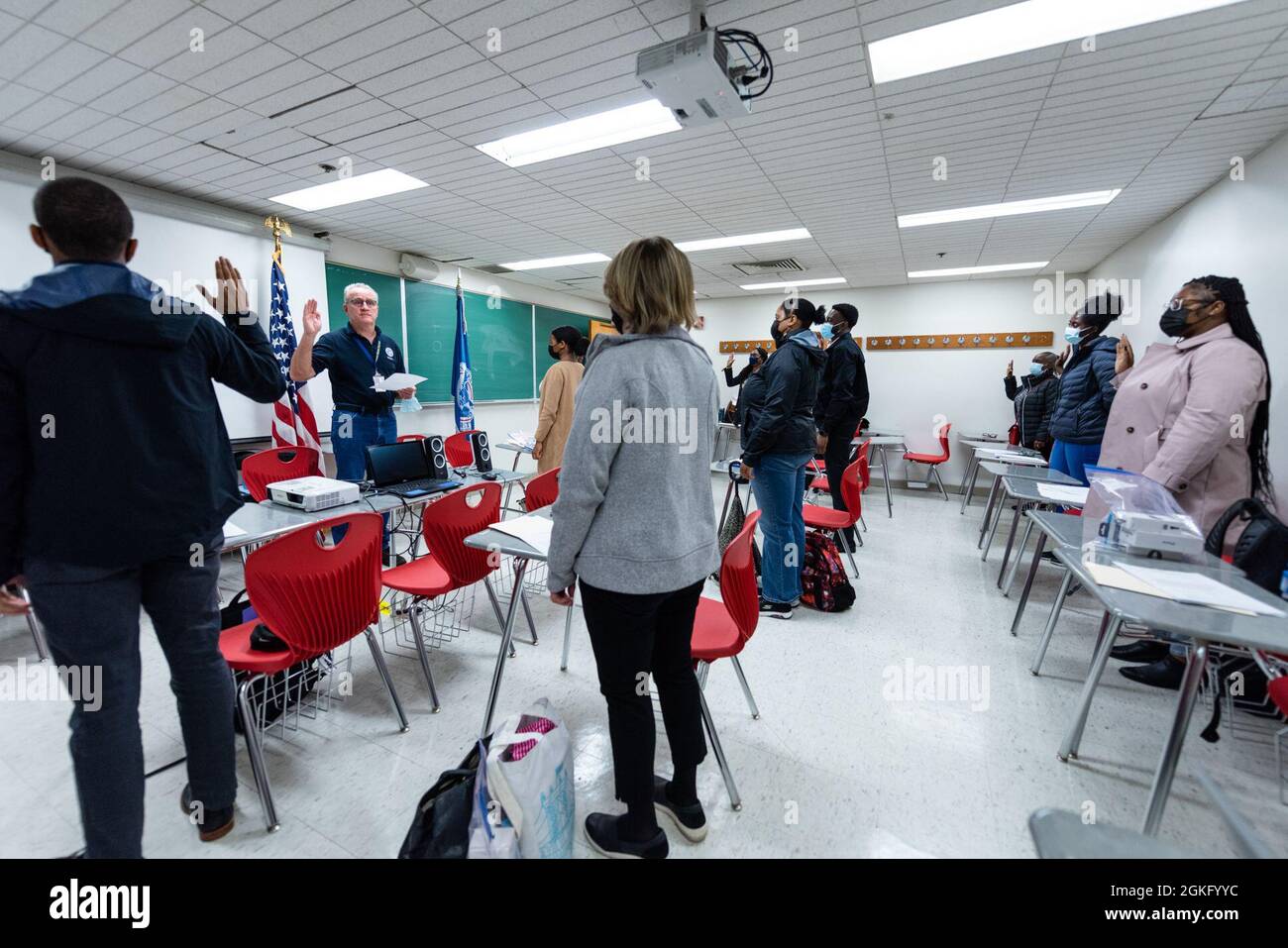 Queens, N.Y., 12. April 2021-- der stellvertretende Leiter der Abteilung für Operationen für Impfzentren der Gemeinschaft, Michael Moriarty, schwört bei neuen lokalen Anstellern. Alle Bundesmitarbeiter müssen vor der Einsetzung in ein gemeinschaftliches Impfzentrum einen Prozess zur Aufnahme, Staging und weiteren Integration (RSOI) abschließen. Die Mitarbeiter erhalten COVID-19-Tests und nehmen an Schulungen für ihren Einsatz Teil. Die FEMA arbeitet mit staatlichen, lokalen, Stammes- und Gebietsregierungen an der kritischen Notwendigkeit, Impfzentren in unterversorgten Gemeinden zu eröffnen. K.C. Wilsey/FEMA Stockfoto
