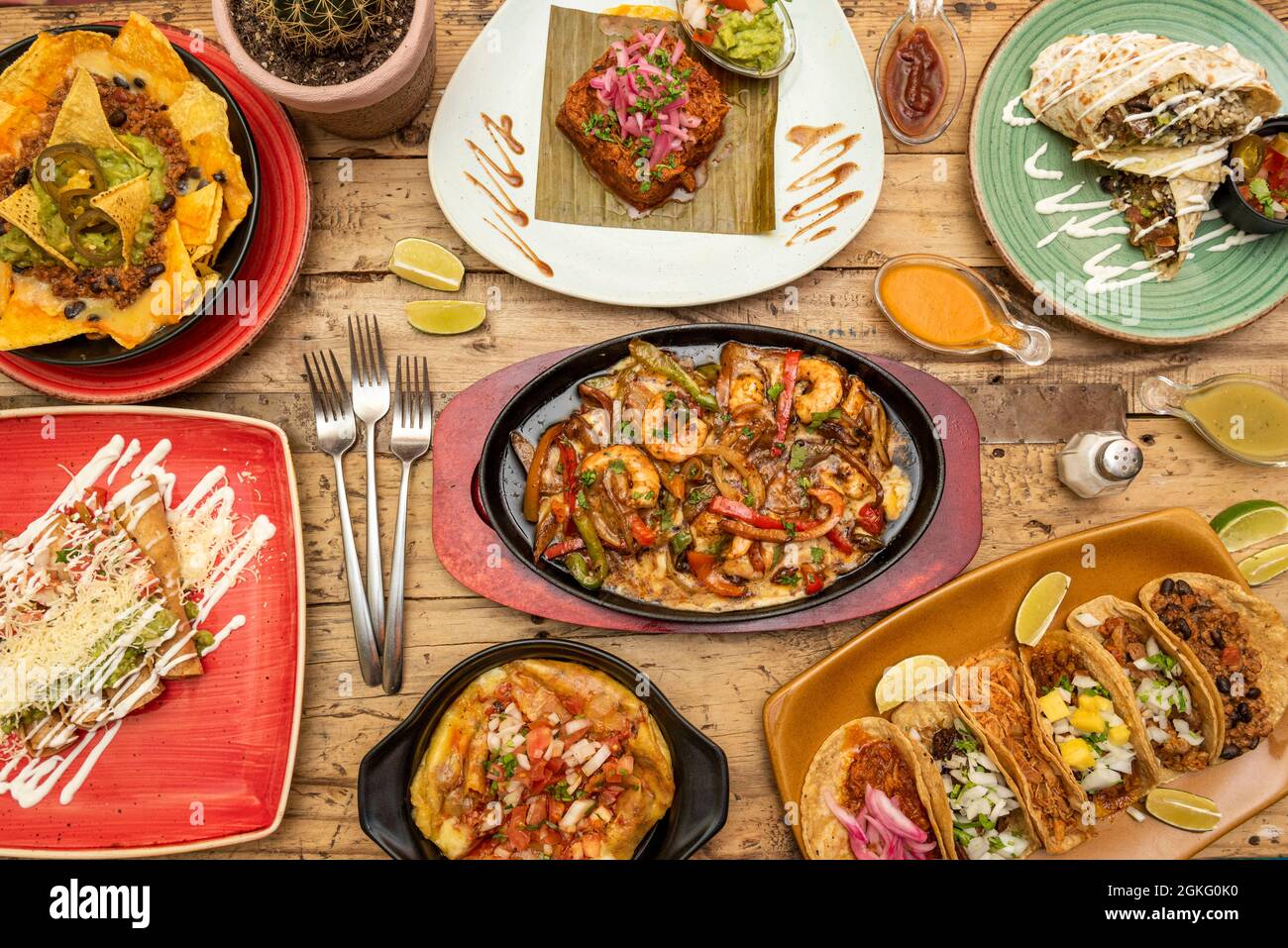Großartige Gerichte mit beliebten mexikanischen Gerichten. Tablett mit verschiedenen Tacos, Rinderdraht, Garnelen Fajitas, goldenen Tacos, Nachos mit Guacamole und Chili, voller Burrito Stockfoto