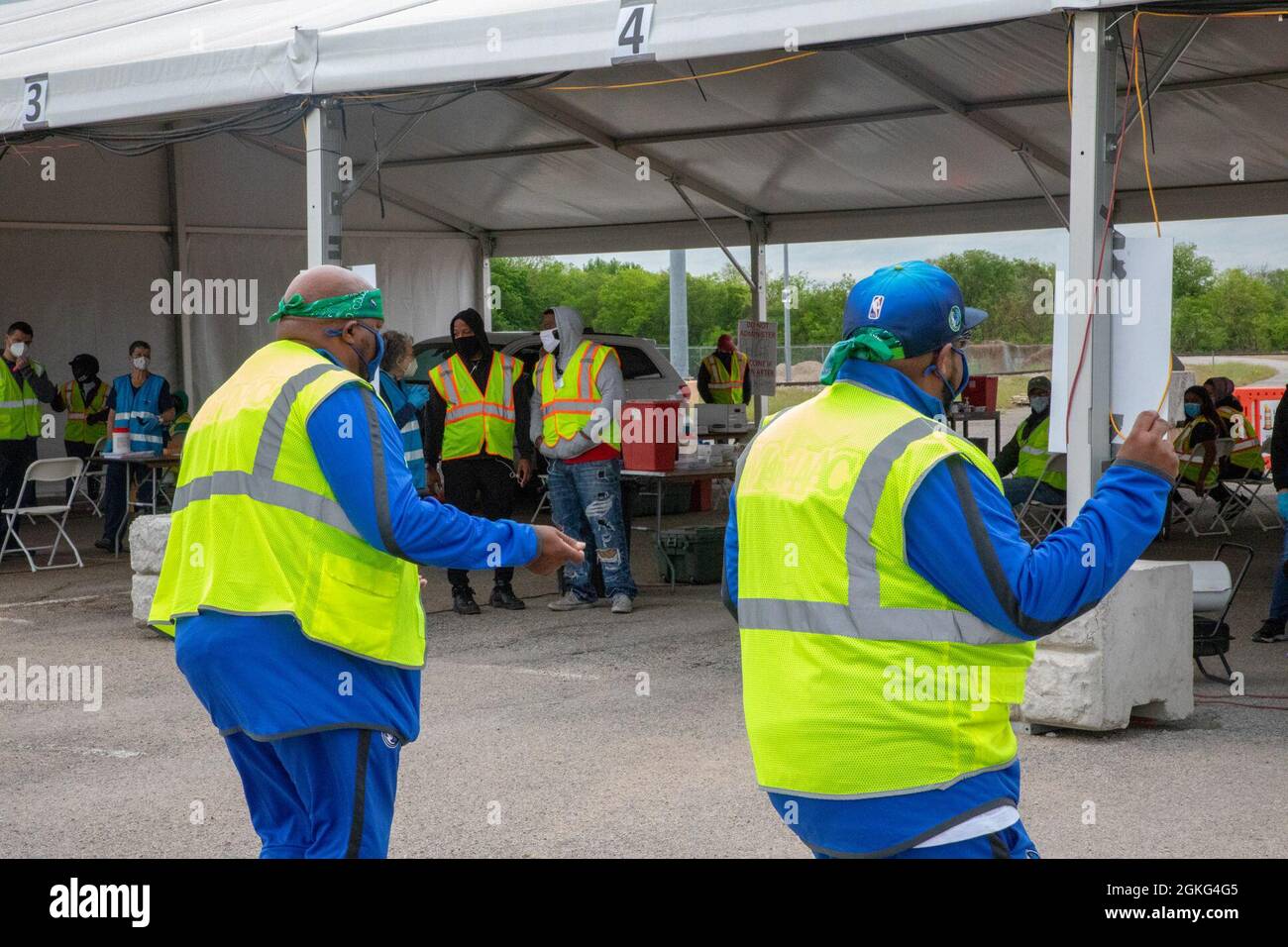 Ben Perkins, Spitzname Red Tiger, (links), und Gerald Walker, Spitzname Juice, (Rechts), Mitglieder der Dallas Mavericks ManiAACs, führen eine Tanzroutine für Freiwillige der Federal Emergency Management Agency (FEMA) im Fair Park Community Vaccination Center (CVC) in Dallas, Texas, am 14. April 2021 durch. Mitglieder der ursprünglichen männlichen Kader von Mavs besuchten den CVC, um die Moral der FEMA-Freiwilligen und Soldaten der US-Armee, die vor Ort arbeiten, zu fördern. Das U.S. Northern Command setzt sich über die U.S. Army North weiterhin dafür ein, der FEMA weiterhin flexible Unterstützung durch das Verteidigungsministerium zu bieten Stockfoto