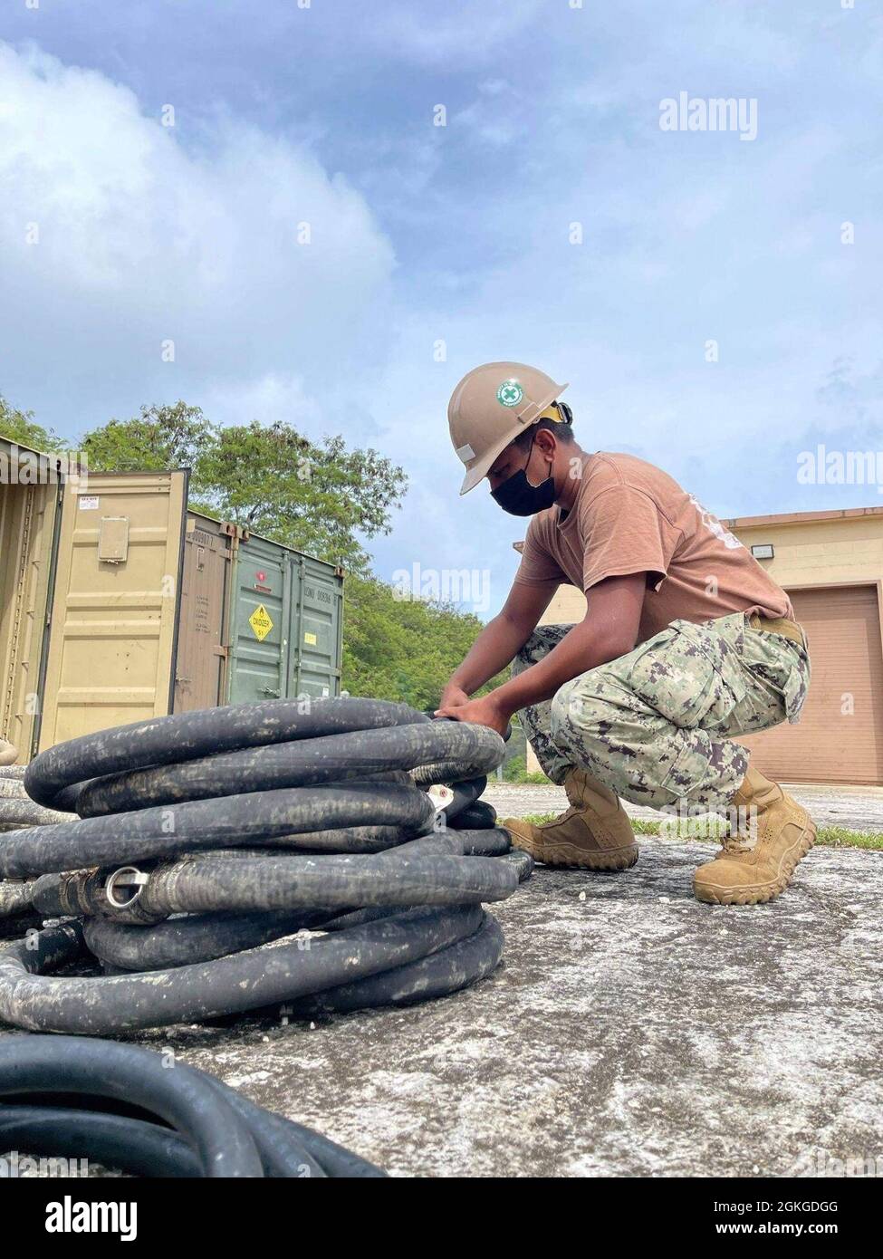 210415-N-ZE595-1002 SANTA RITA, Guam (15. April 2021) HilfemanöreBaumann Lehrling Yashneel Achari, dem Marine Mobile Construction Bataillon (NMCB) 4 zugeordnet, bereitet den Versorgungsschlauch des Leichtwasserreinigungssystems (LWPS) zur Lagerung vor. LWPS ist ein gut transportierbares und in sich geschlossenes System, das in der Lage ist, den Trinkwasserbedarf unter einer Vielzahl von strengen Bedingungen zu erfüllen. NMCB-4 wird im gesamten Indo-Pazifik-Raum eingesetzt, um größere Kampfeinsätze, humanitäre Hilfe und Katastrophenhilfe zu unterstützen und allgemeine Ingenieursleistungen und zivile Einrichtungen zu erbringen Stockfoto