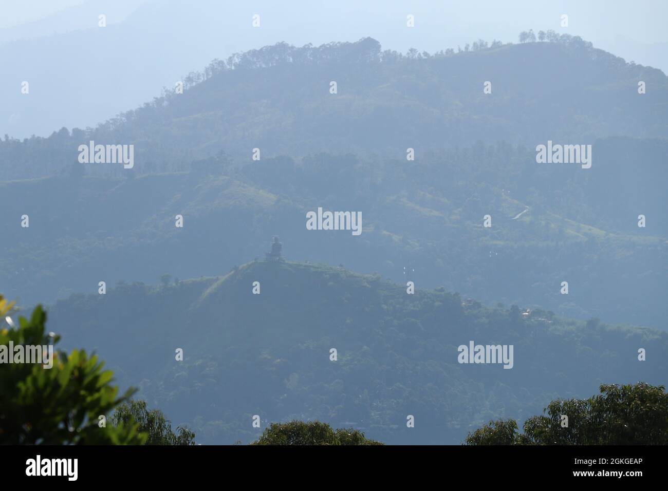 Neblige Aussicht auf die Berge mit versteckter Buddha-Statue Stockfoto