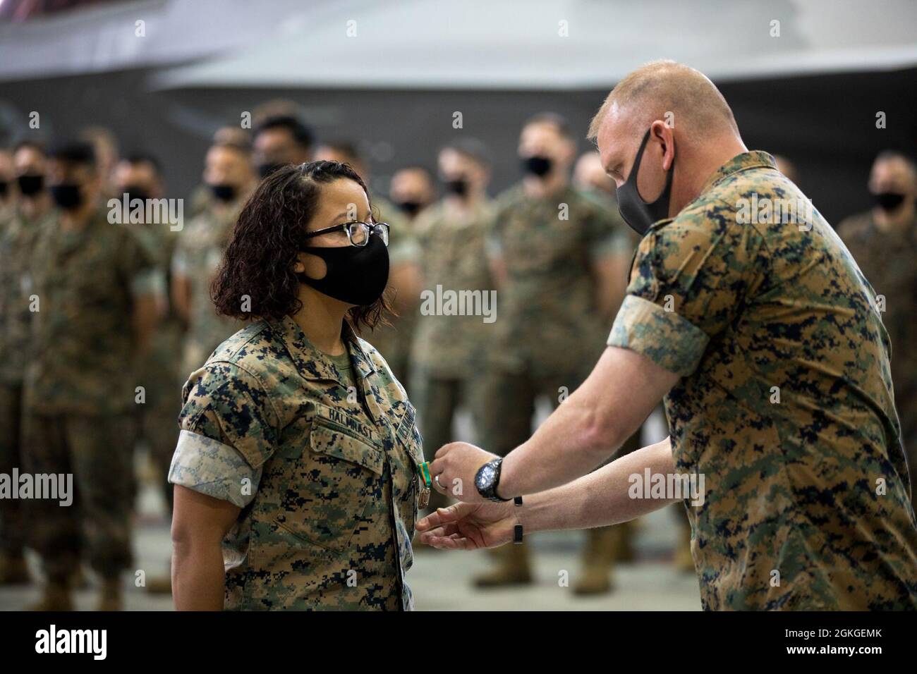 U.S. Marine Corps CPL. Charlecia Halmrast, ein administrativer Spezialist, links, mit Marine Fighter Attack Squadron (VMFA) 242, links, erhält eine Medaille des Marine Corps Achievement Medal von LT. Col. Michael Wyrsch, Kommandant von VMFA-242 bei der Marine Corps Air Station Iwakuni, Japan, 16. April 2021. Marineinfanteristen und Segler mit VMFA-242 wurden für ihre überlegene Leistung während des Übergangs von älteren F/A-18-Hornet-Flugzeugen zu F-35B-Flugzeugen der fünften Generation mit Medaillen für die Leistungen der Marine und des Marine Corps ausgezeichnet. Stockfoto