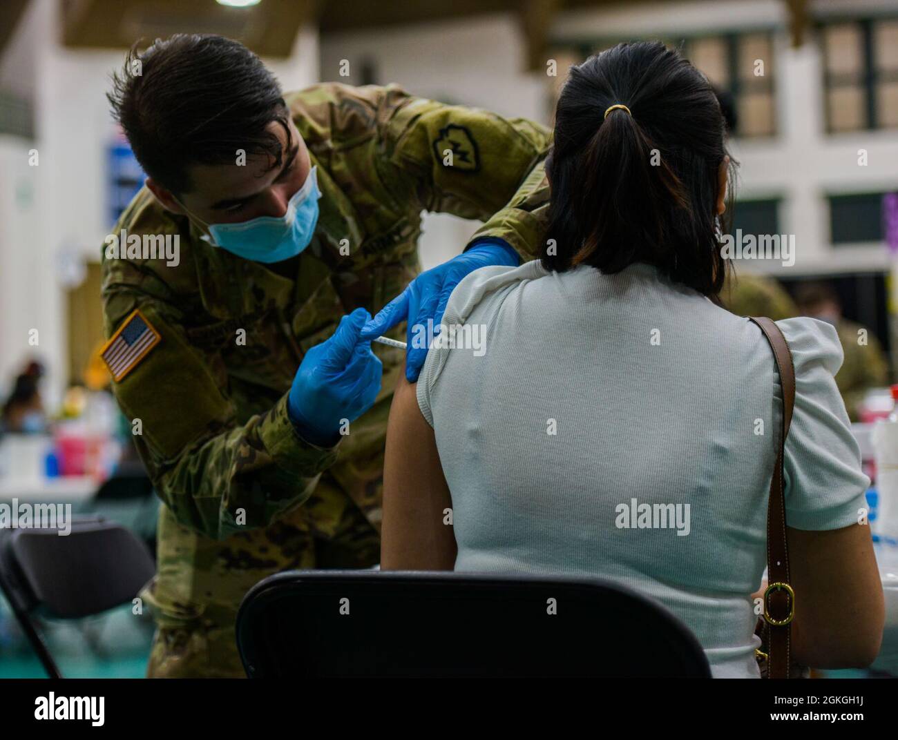 MANGILAO, Guam (16. April 2021) – PFC. Ethan Van Veldhuizen, ein Kampfmediziner, der der 25. Infanterie-Division zugewiesen ist, verabreicht einen COVID-19-Impfstoff zur Unterstützung des COVID-19-Impfteams des Gesundheitsministeriums von Guam (DPHSS) in einer Impfklinik im Feldhaus der Universität von Guam Calvo. Das US-amerikanische Indo-Pacific Command über die US Army Pacific ist weiterhin bestrebt, die Federal Emergency Management Agency im Rahmen der Reaktion der gesamten Regierung auf COVID-19 weiterhin flexibel zu unterstützen. Stockfoto