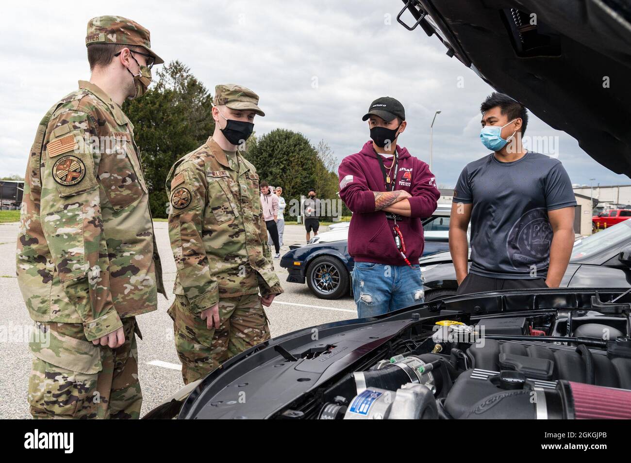 Die Mitglieder des Teams Dover diskutieren während der Auto- und Fahrradshow am Wingman Day auf der Dover Air Force Base, Delaware, 16. April 2021, über einen Automotor. 36 Autos und vier Motorräder kamen in die Show. Stockfoto