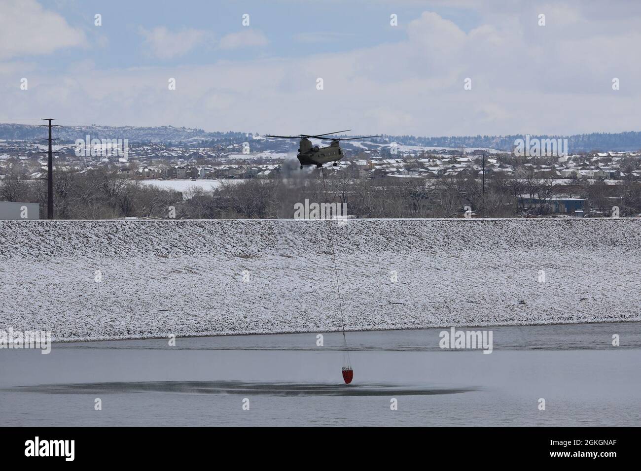 Ein US Army CH-47 Chinook und Crew der 2. Brigade, 135. General Support Aviation, Colorado Army National Guard, führen Wassereimer-Tropfen über dem Chatfield Reservoir in Littleton, Colorado, durch, 17. April 2021. LUH-72 Lakota, UH-60 Black Hawk und CH-47 Chinook Flugcrews flogen im Rahmen der jährlichen Wildland Fire Training Conference über die Metropolregion Denver. Stockfoto