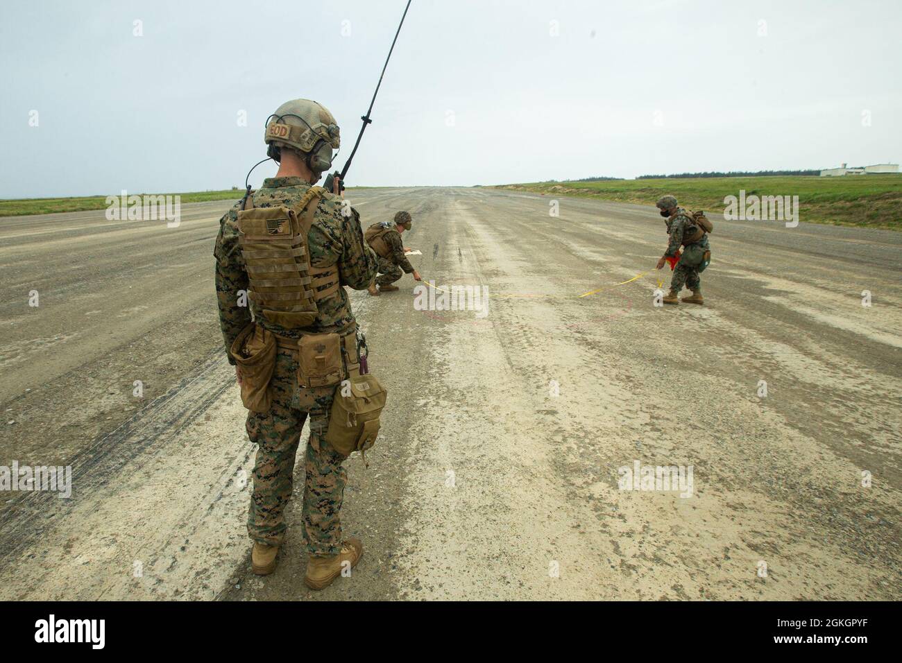 US-Marineinfanteristen mit dem Damage Assessment Team, das dem Marine Wing Support Squadron (MWSS) 172 zugewiesen ist, messen einen simulierten Mörserkrater auf einer Start- und Landebahn, während sie während einer von MWSS-172 in der IE Shima Trainingseinrichtung veranstalteten Basic Recovery After Attack (BRAAT) Trainingsveranstaltung eine Kampfbereitschaft des Marine Corps (MCCRE) messen. Okinawa, Japan, 17. April 2021. Das MCCRE schafft eine herausfordernde, realistische Trainingsumgebung, in der kampfbereite Kräfte erzeugt werden, die jederzeit als eingesetzte Einheit operieren können. Stockfoto